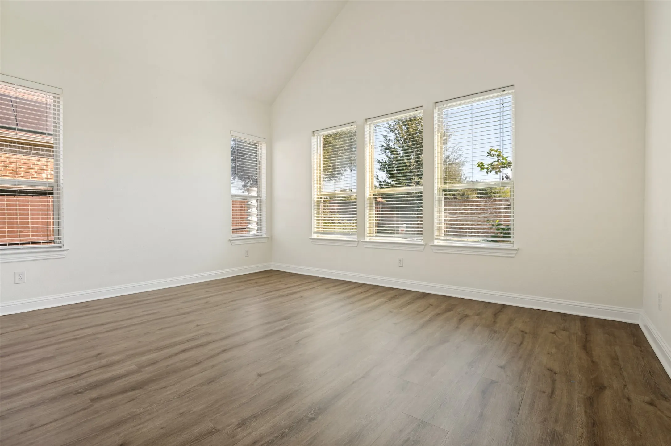 Bright, light-filled room with vaulted ceilings and multiple windows offering natural illumination