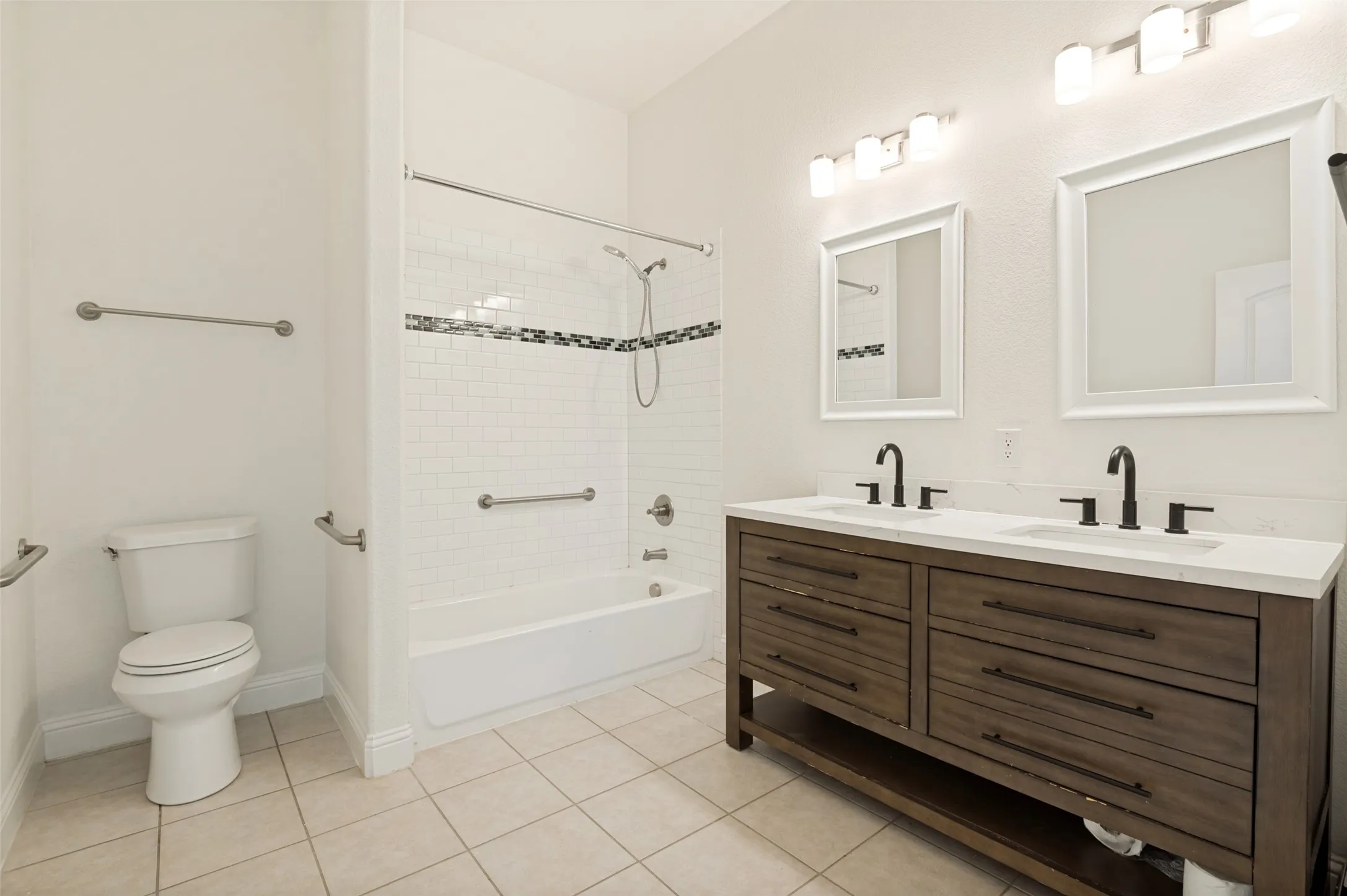 Dual vanity with dark wood-finish cabinetry, white countertops, and matte black fixtures