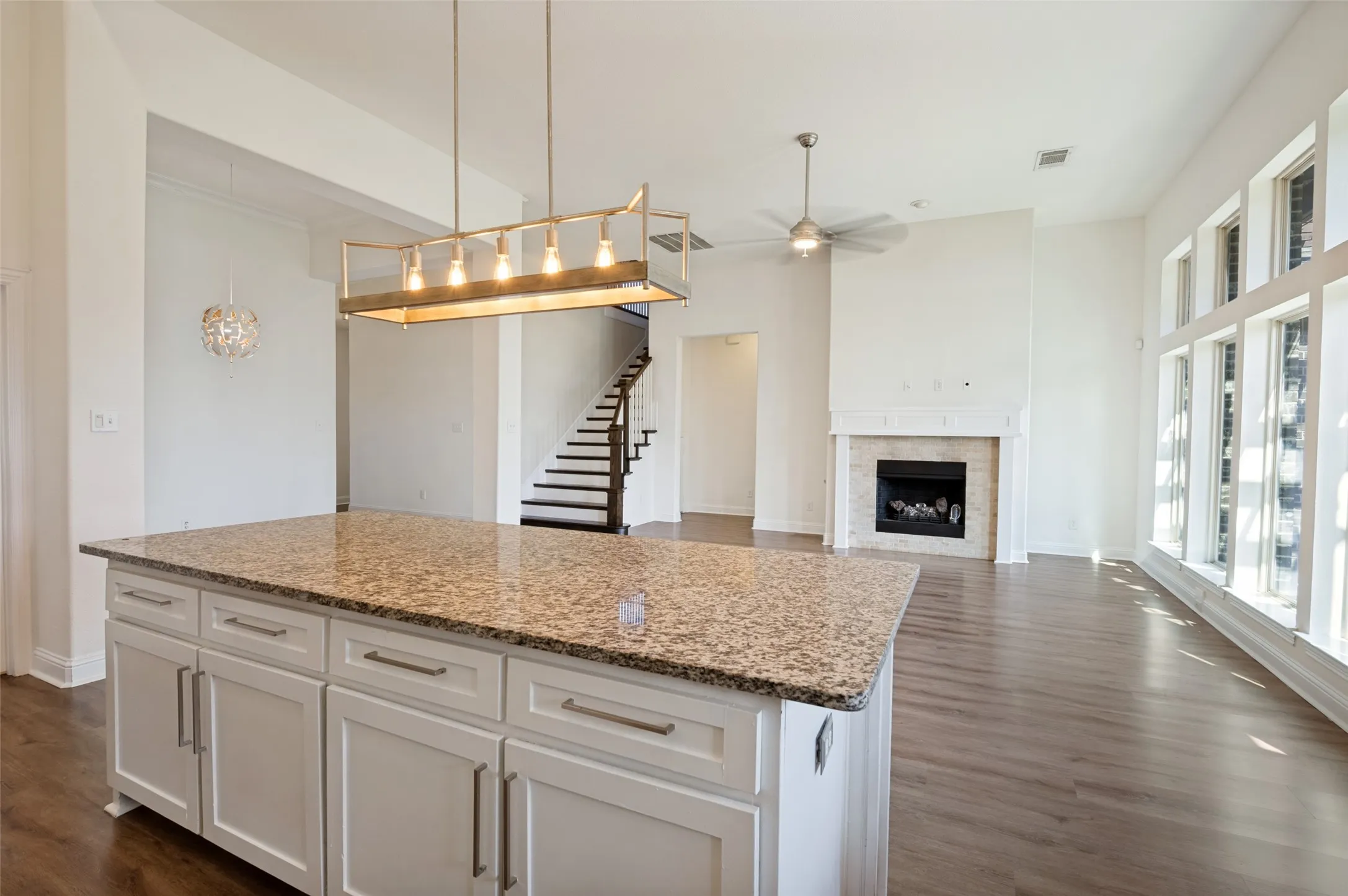 Kitchen island with granite countertop and white cabinetry
