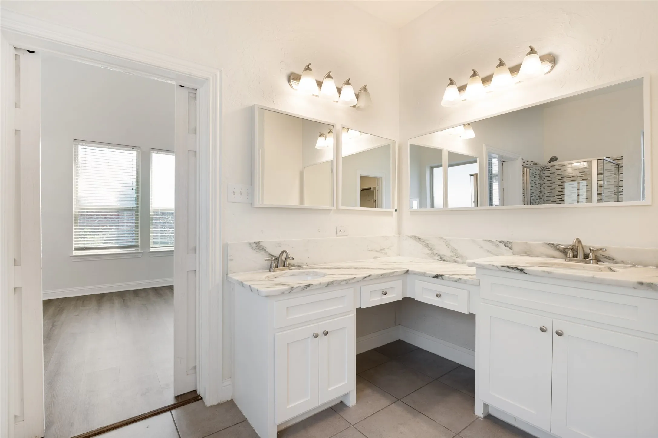 Dual sink vanity with quartz countertops, white cabinetry, and brushed nickel fixtures