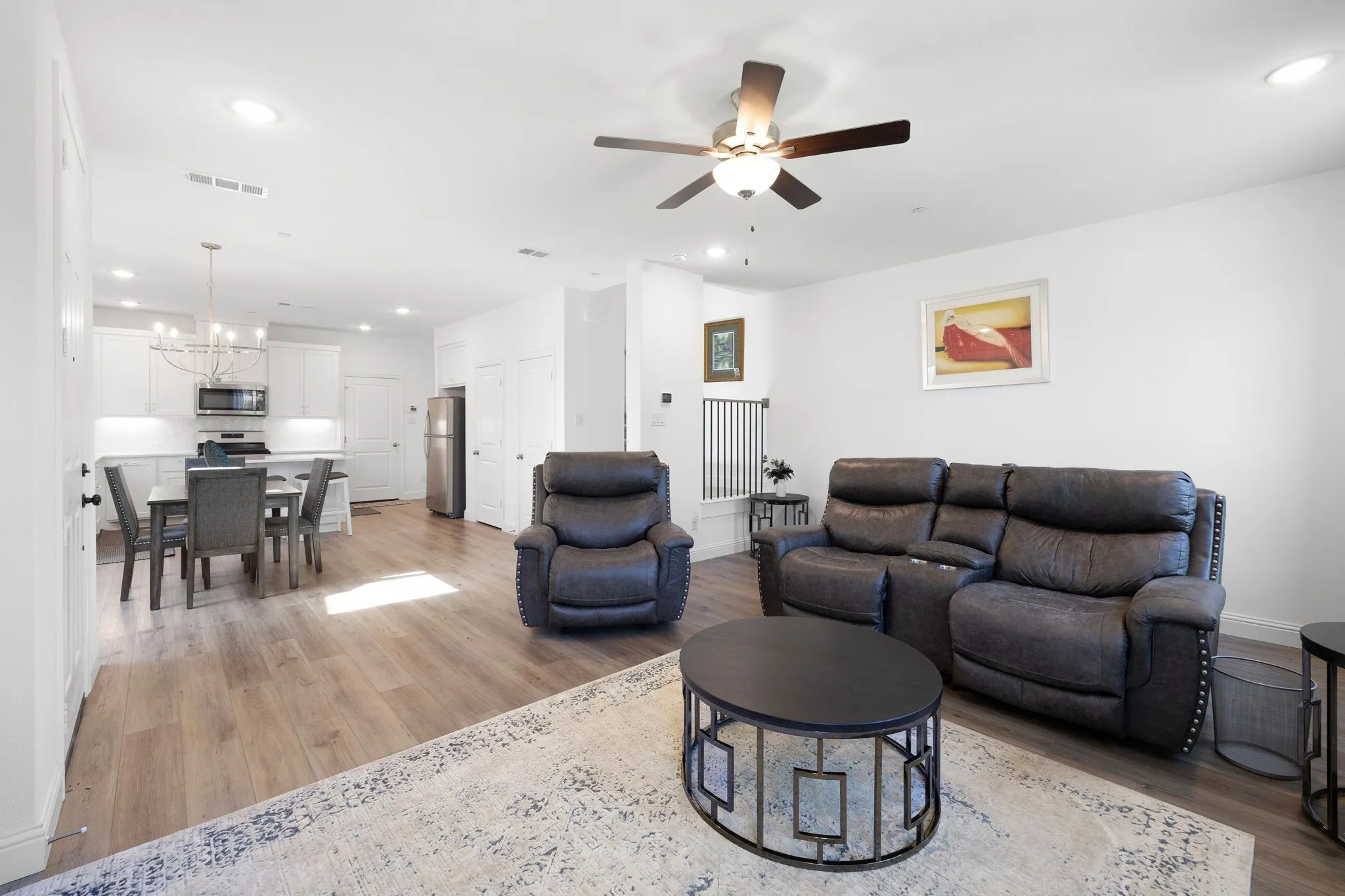 Open-concept living space featuring wood-finish flooring, recessed lighting, and a ceiling fan