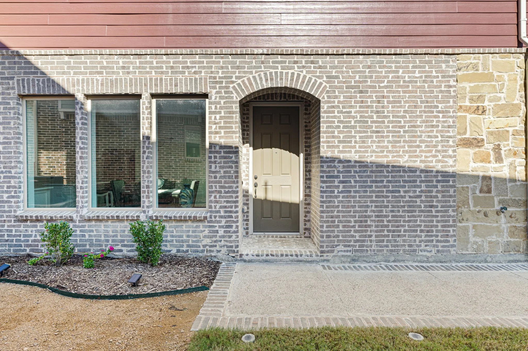 Brick and stone exterior featuring an arched entryway