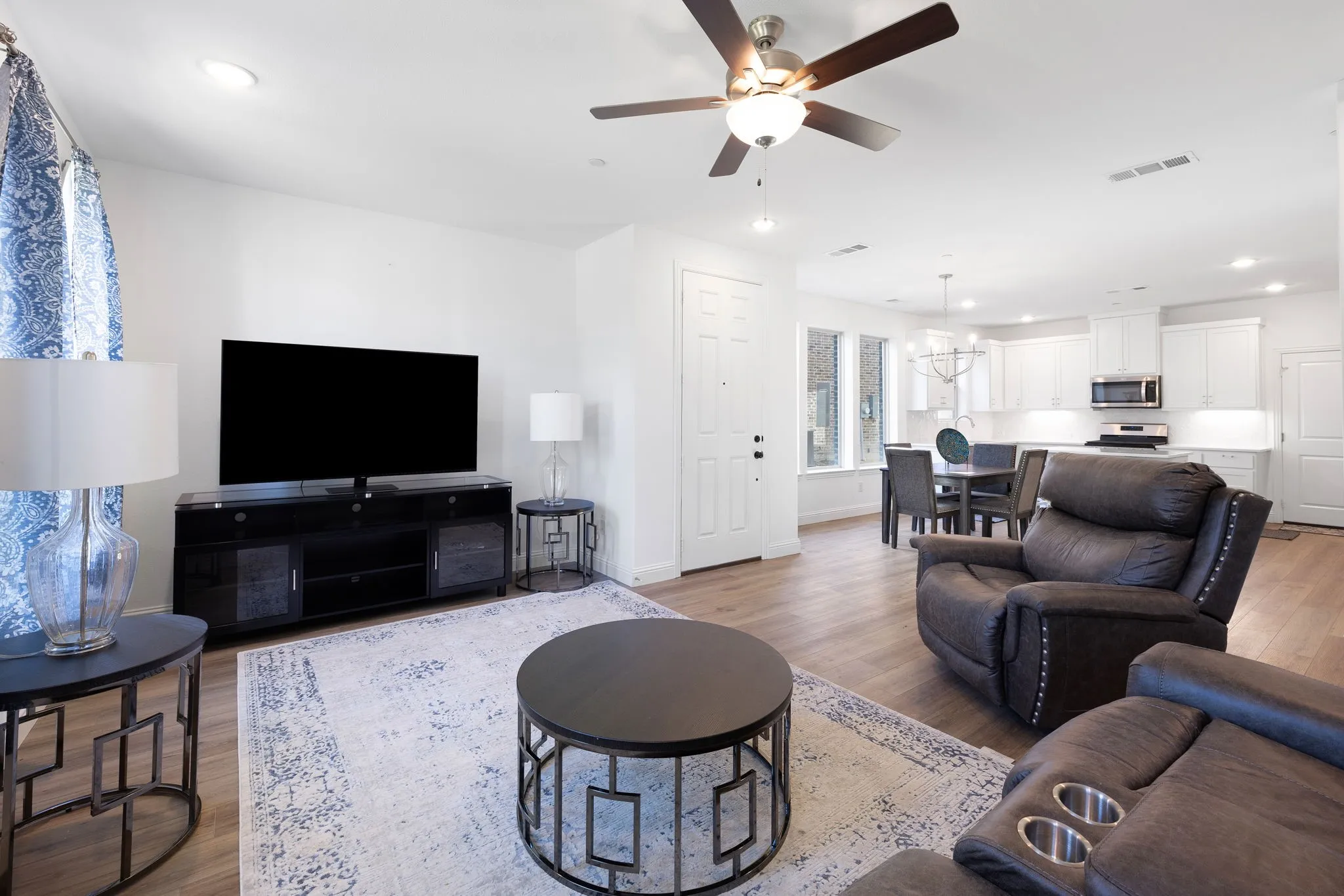 Open-concept living space featuring wood-finish flooring, recessed lighting, and a ceiling fan