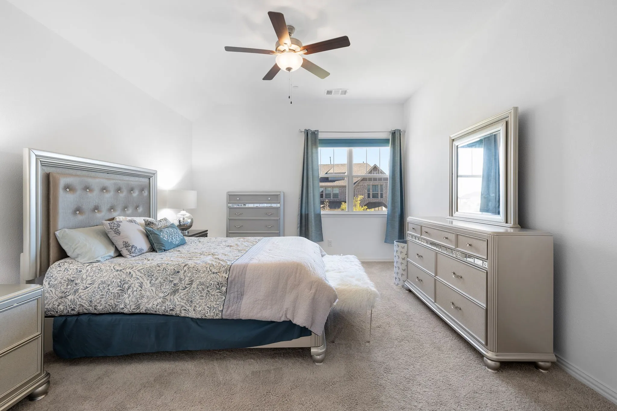 Carpeted flooring, vaulted ceiling, and a ceiling fan with integrated lighting