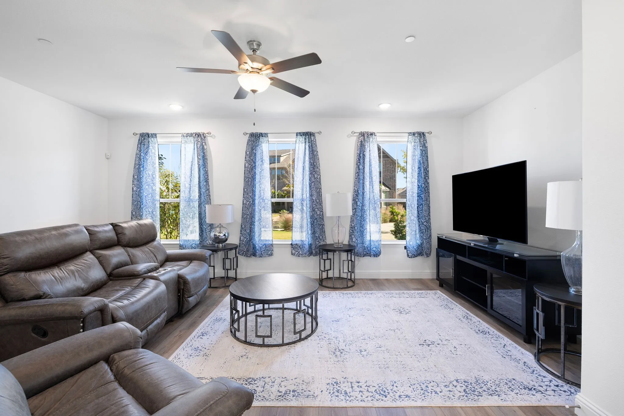 Recessed lighting, ceiling fan light fixture, wood-finish flooring, three windows with natural light, media console with storage