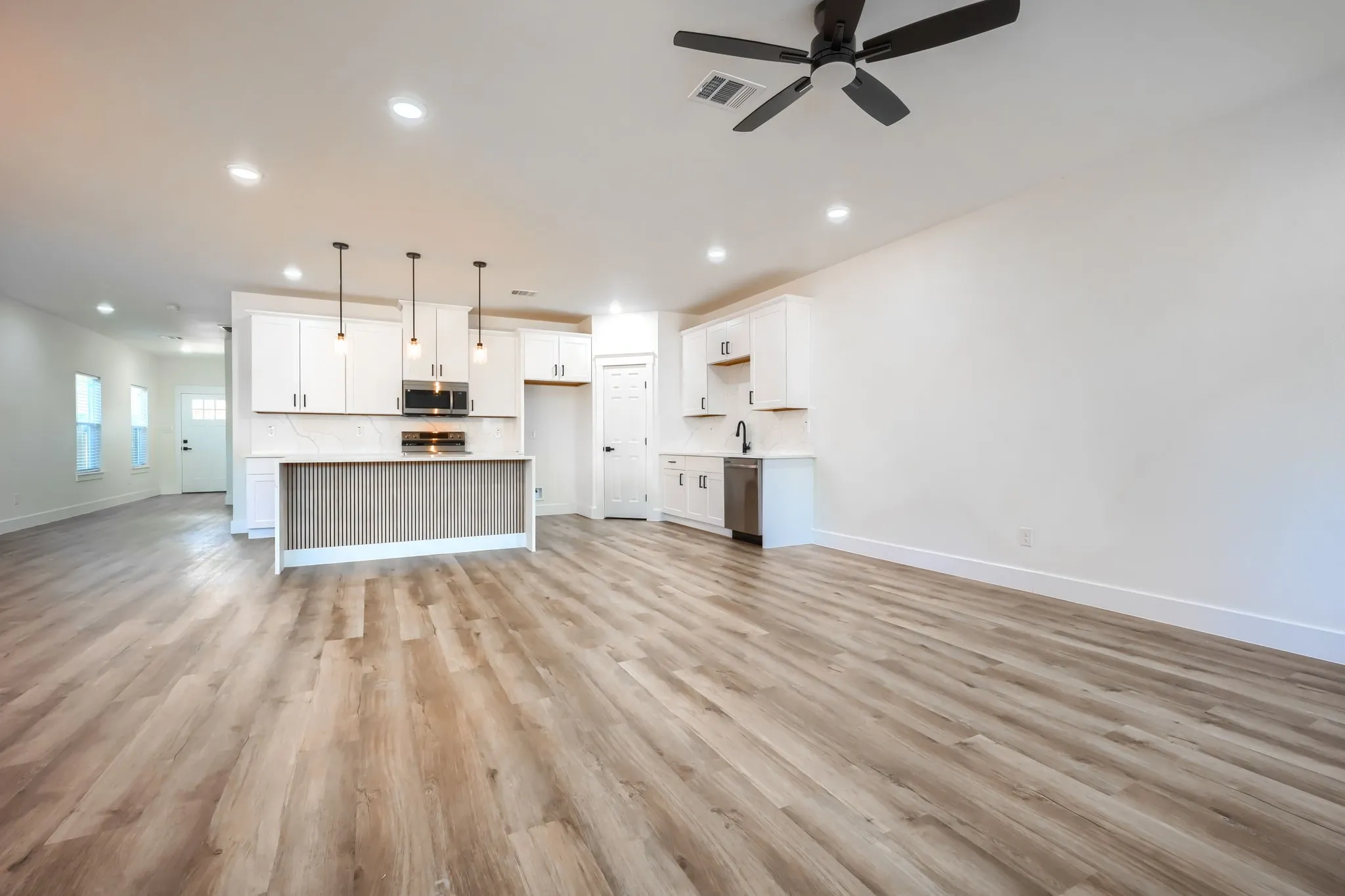 Open-concept living space featuring wood-finish flooring, recessed lighting, and a contemporary ceiling fan