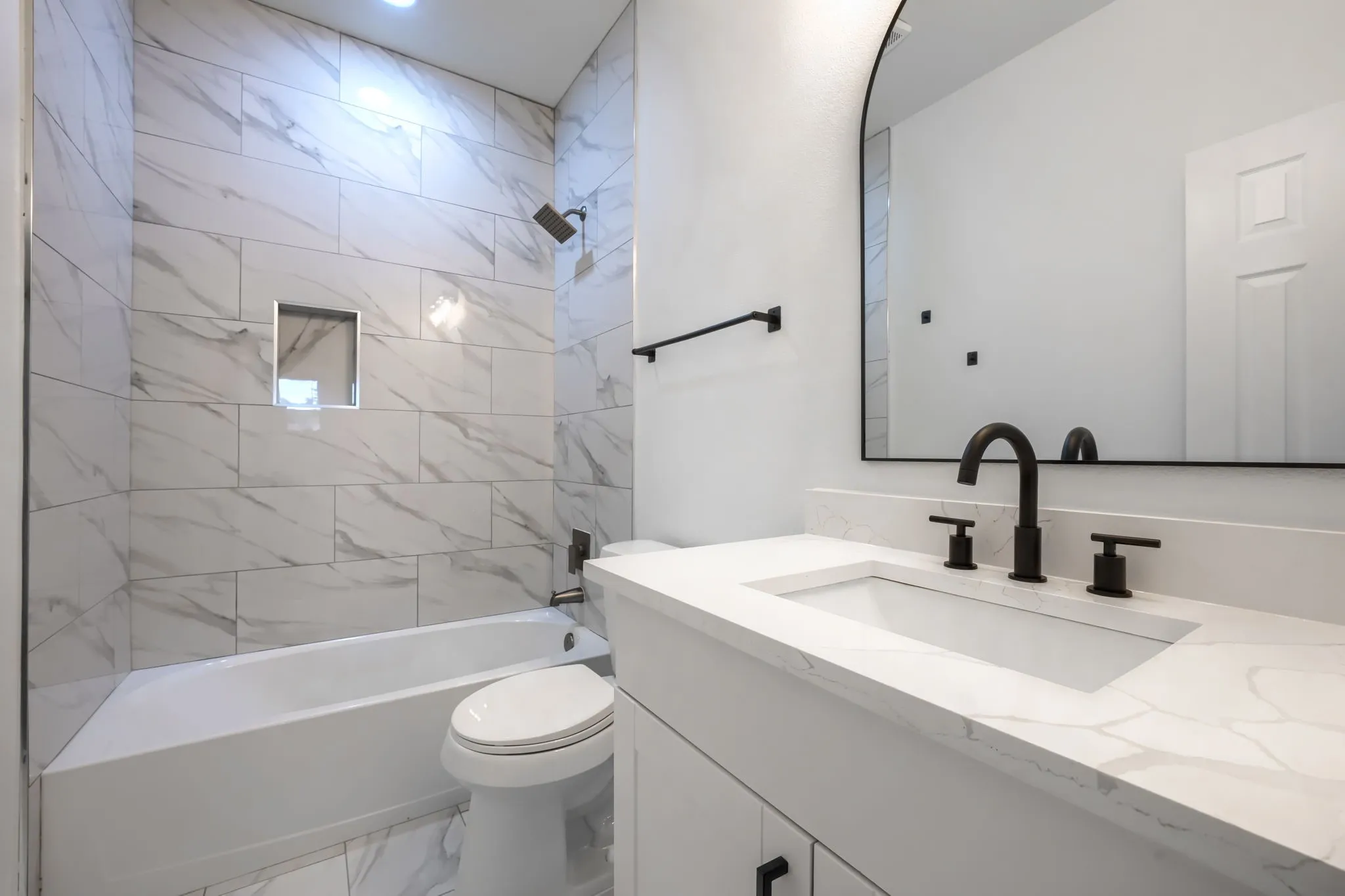 White vanity with integrated rectangular sink and stone-finish countertop