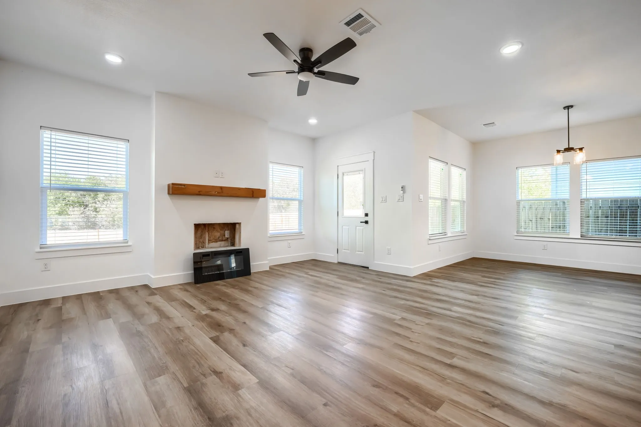 Wood-finish flooring throughout, recessed lighting, ceiling fan, and a light-filled interior