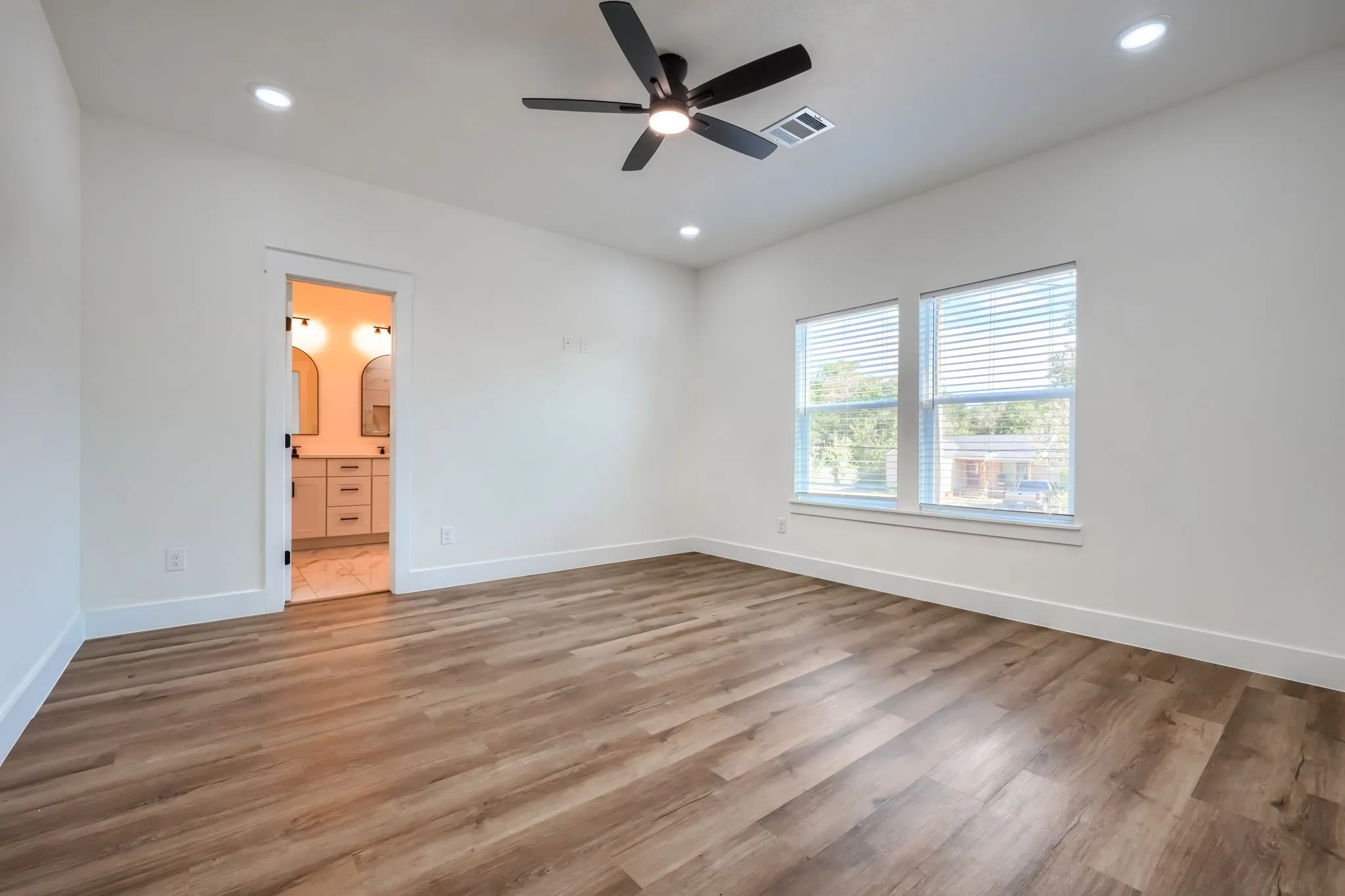 Spacious room with wood-finish flooring, recessed lighting, and a ceiling fan