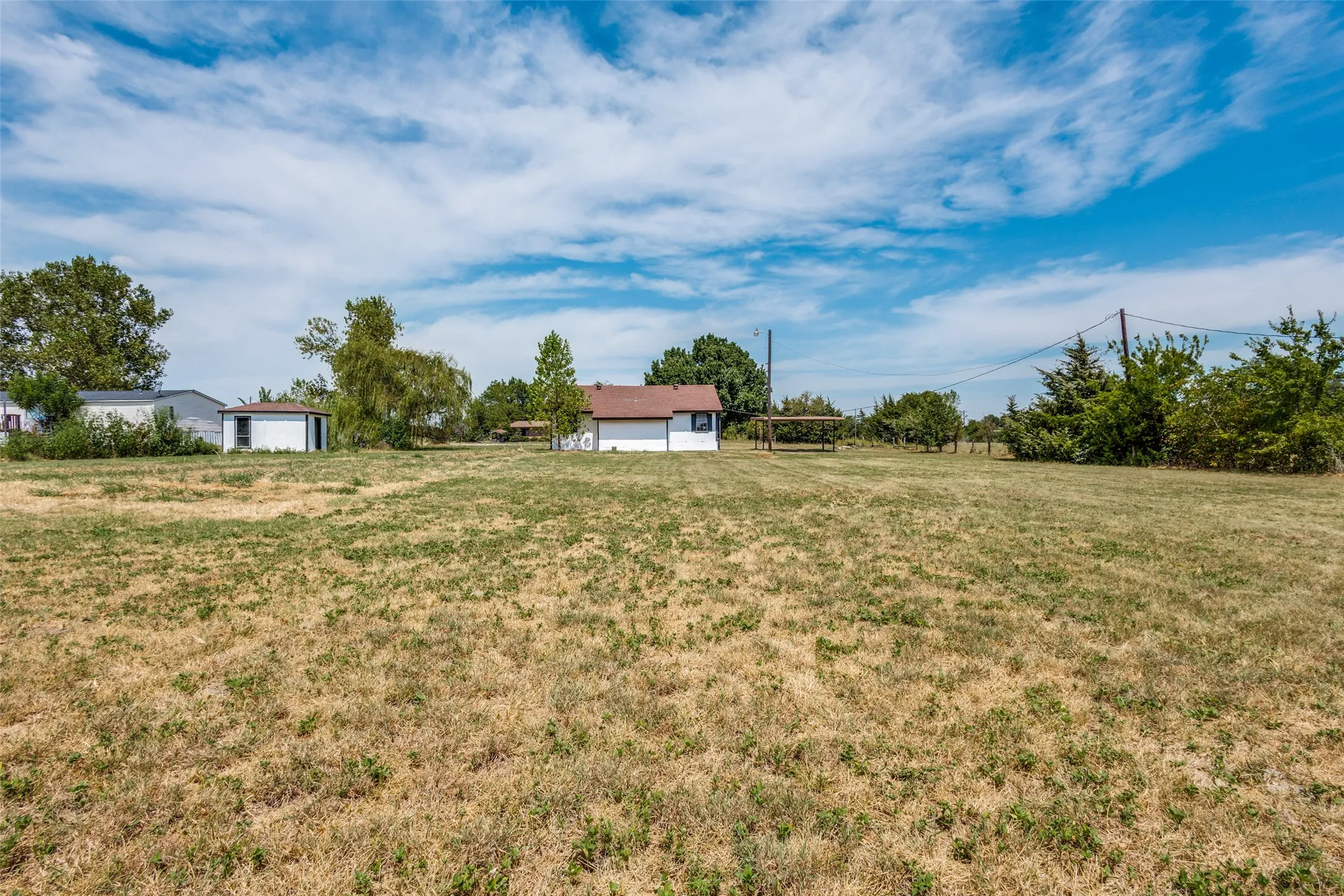 Expansive lot with multiple outbuildings and mature trees