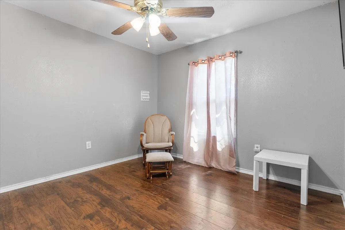 Original -Bedroom 2 Wood-finish flooring, ceiling fan with integrated lighting, and neutral wall tones