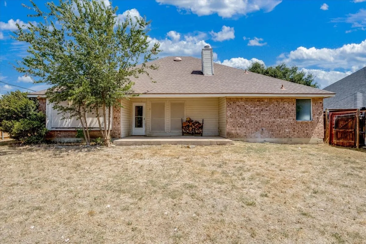 Expansive backyard with a concrete patio, brick and siding exterior, and a privacy fence
