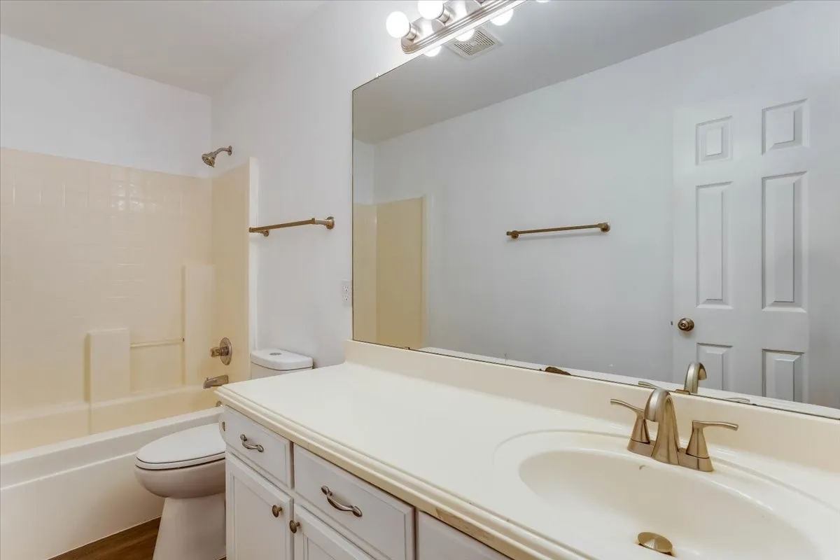 White vanity with brushed nickel hardware, integrated sink, and brushed nickel faucet