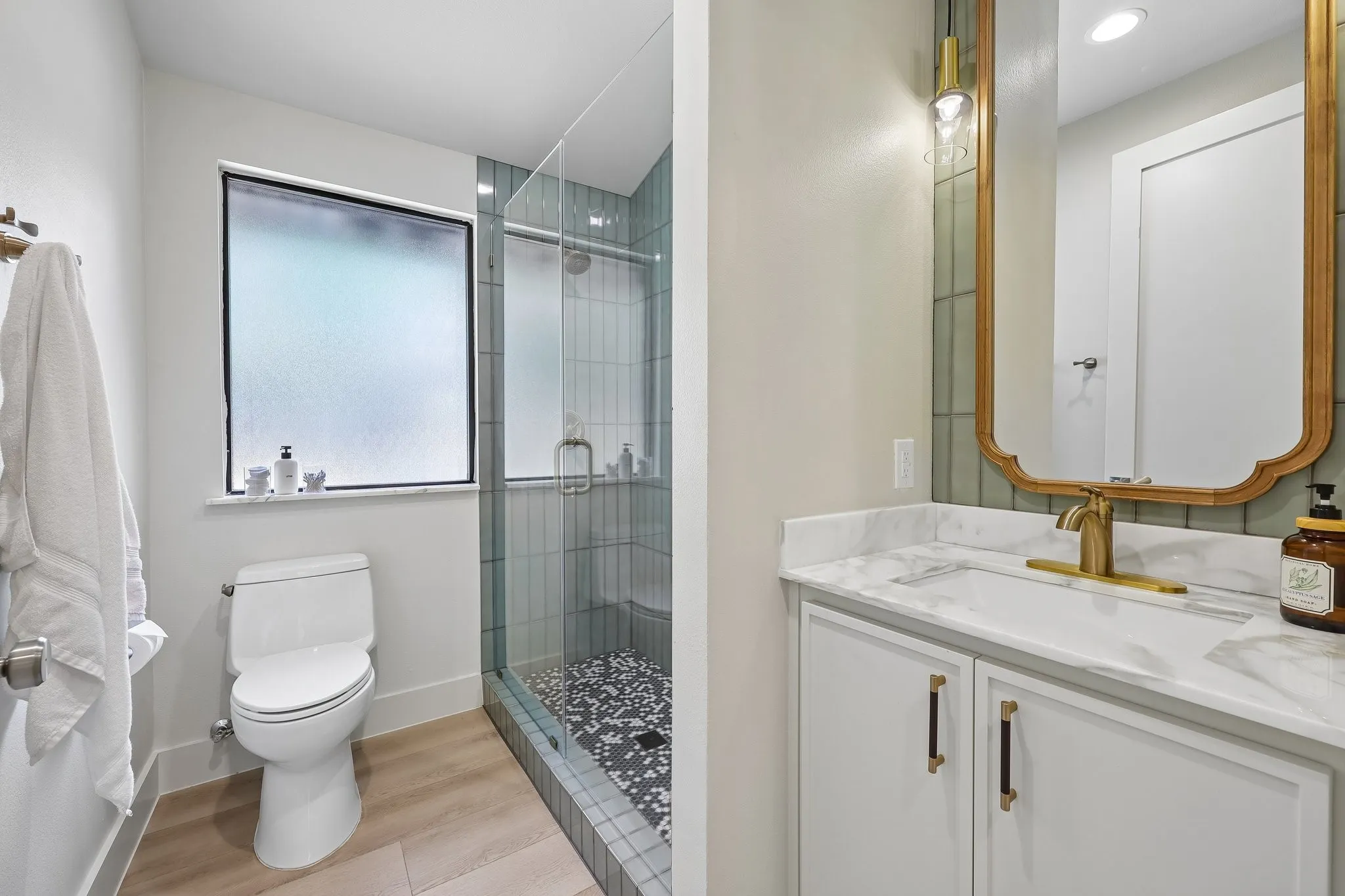 Sleek secondary bathroom with easy walk in shower. All high end fixtures: Delta faucets & Kohler toilets.