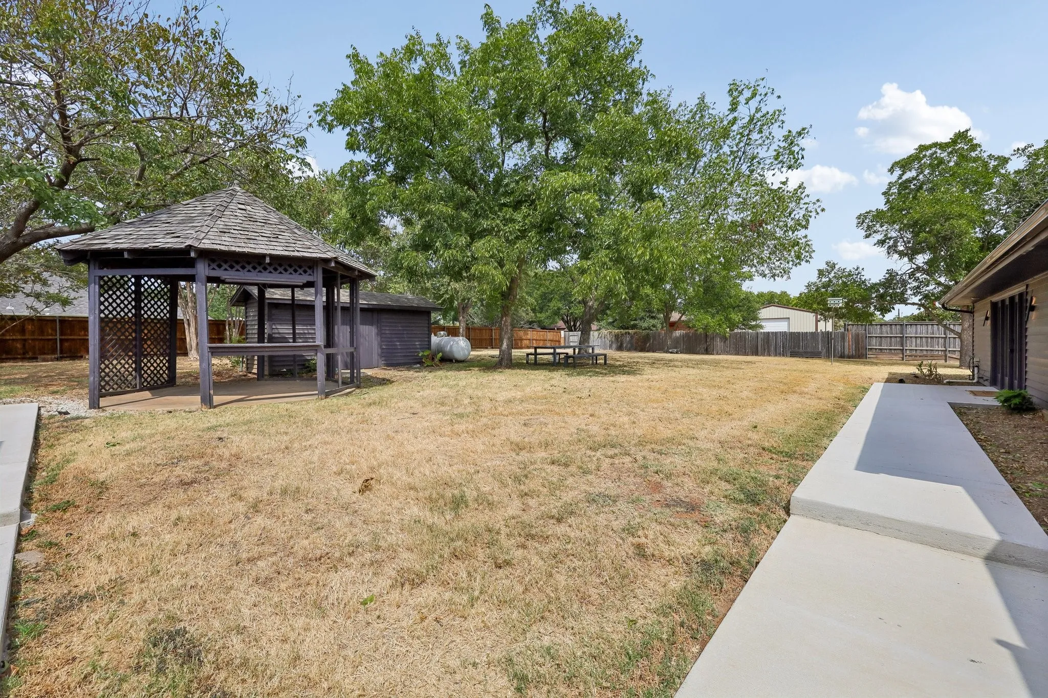 Old growth trees make this yard inviting. Cornhole, anyone?