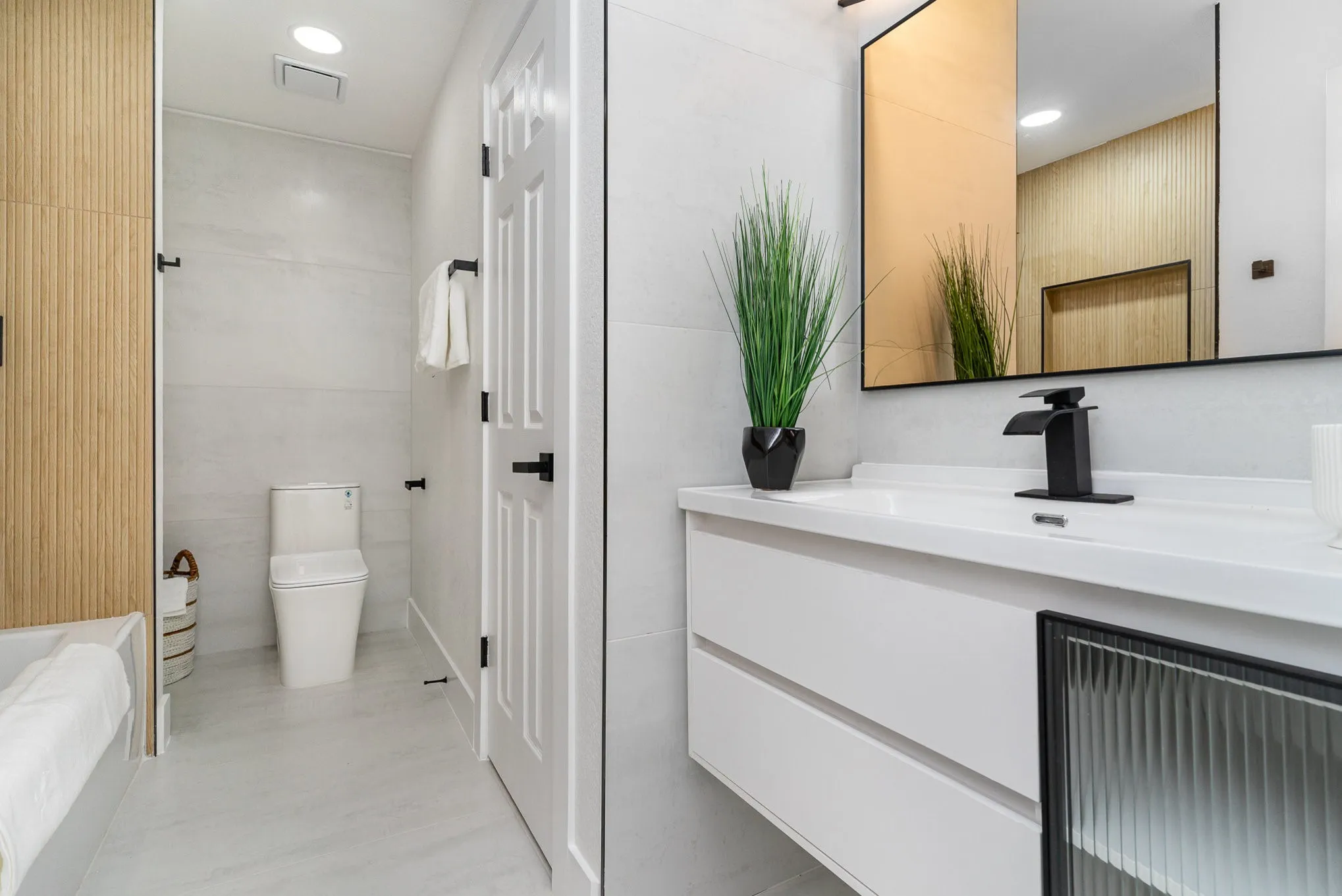 Bathroom with tile walls, vanity, and toilet
