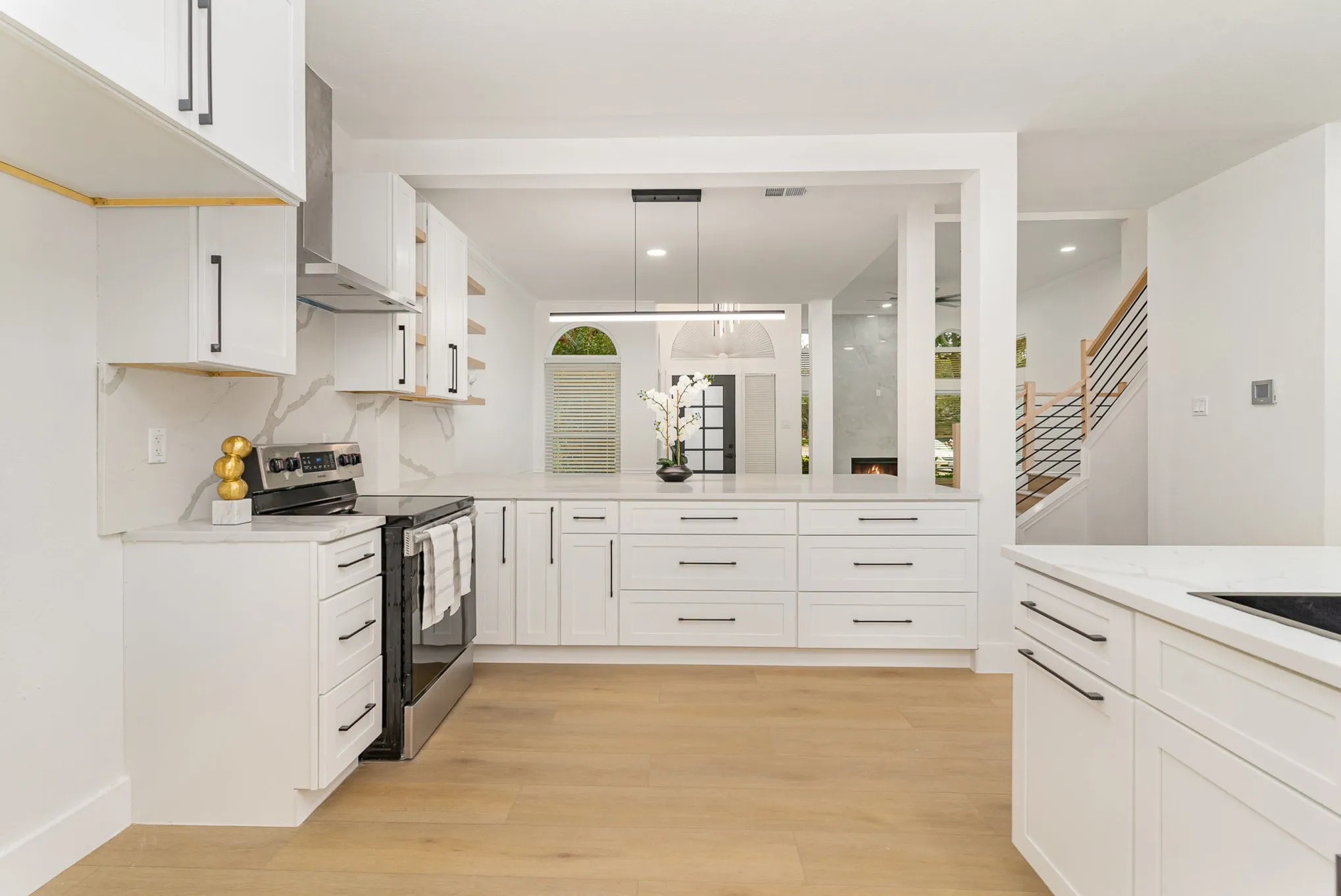 Kitchen featuring pendant lighting, light wood-type flooring, white cabinetry, and stainless steel electric stove