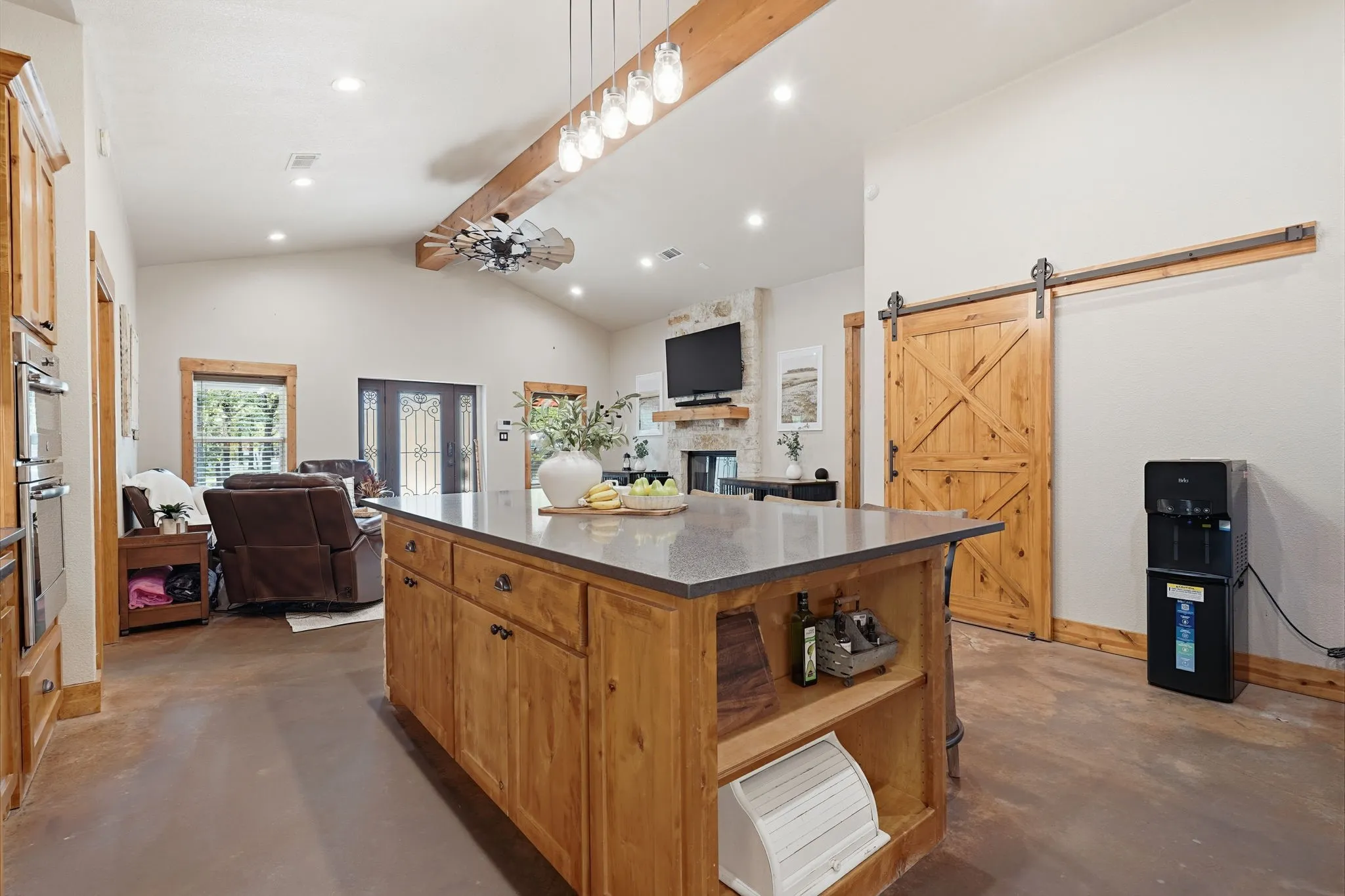 Central kitchen island with a dark countertop and wood cabinetry