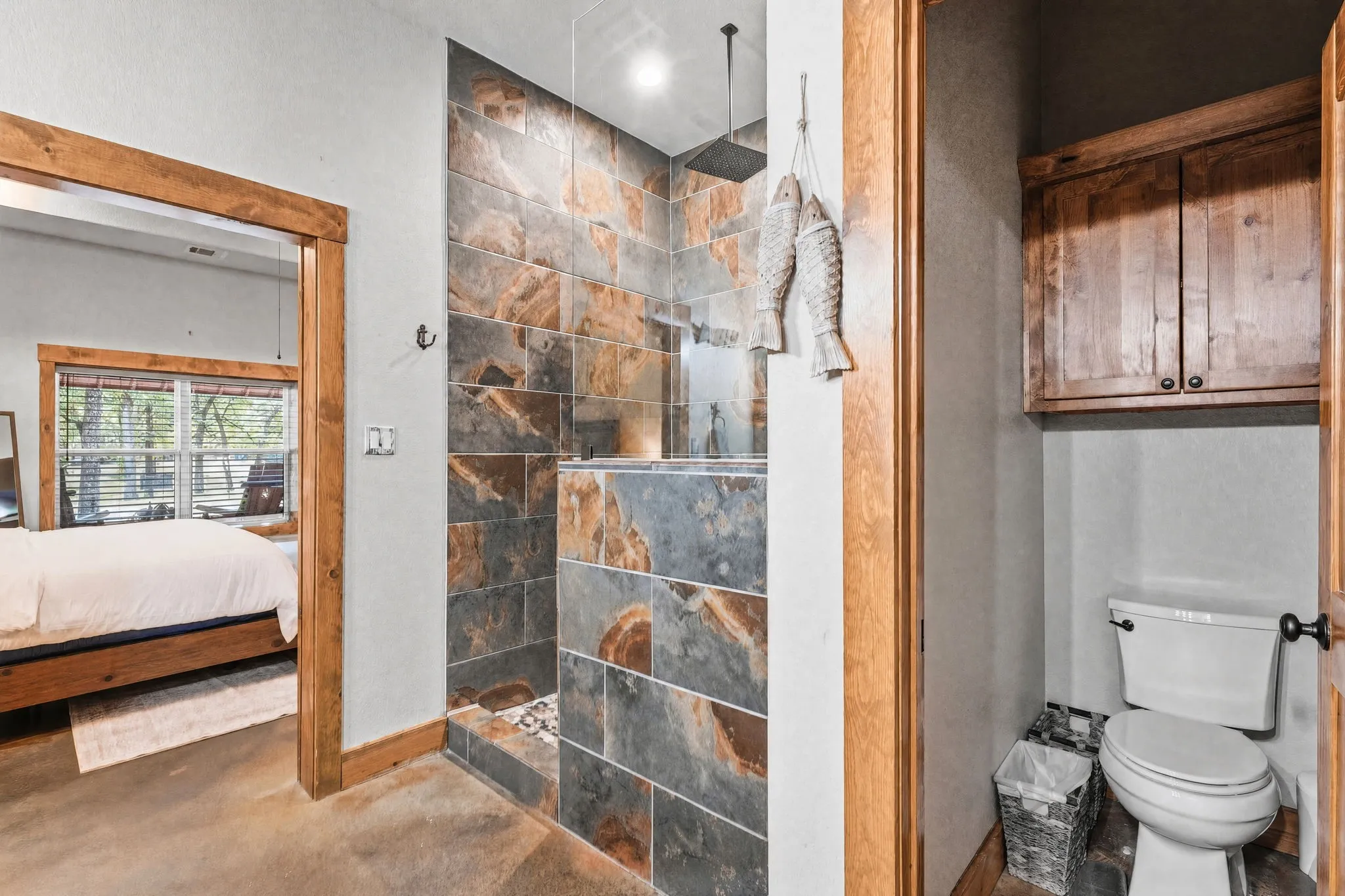 Floor-to-ceiling slate tile shower with glass enclosure and rain shower head
