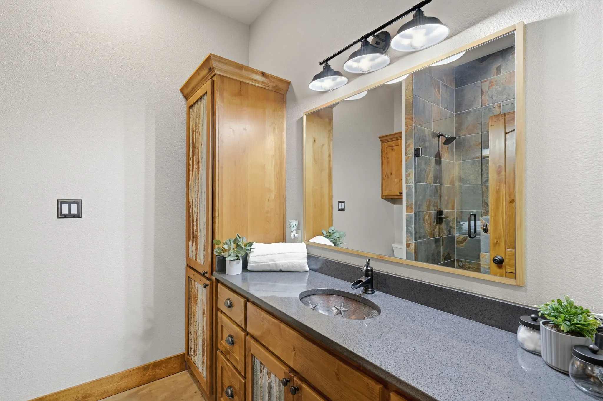 Custom vanity with a single basin sink, matte black faucet, and stone countertop