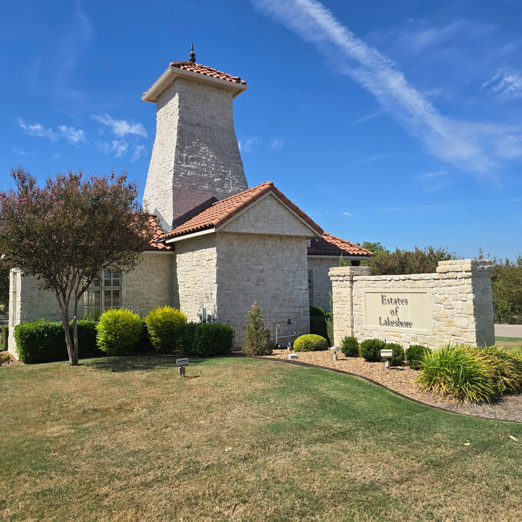 Stone exterior with a prominent tower feature and a red tile roof