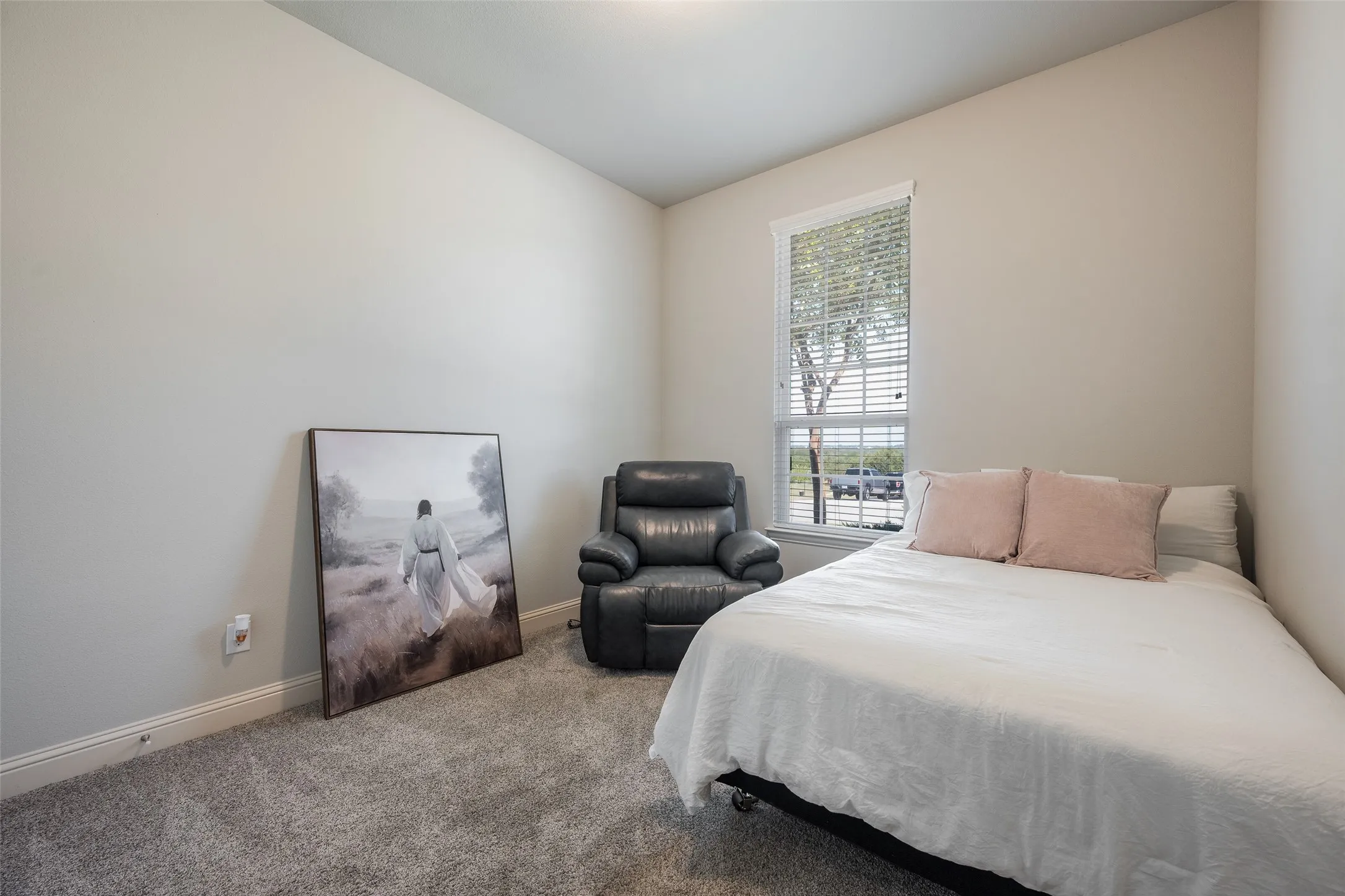 Carpeted room with a single window featuring horizontal blinds