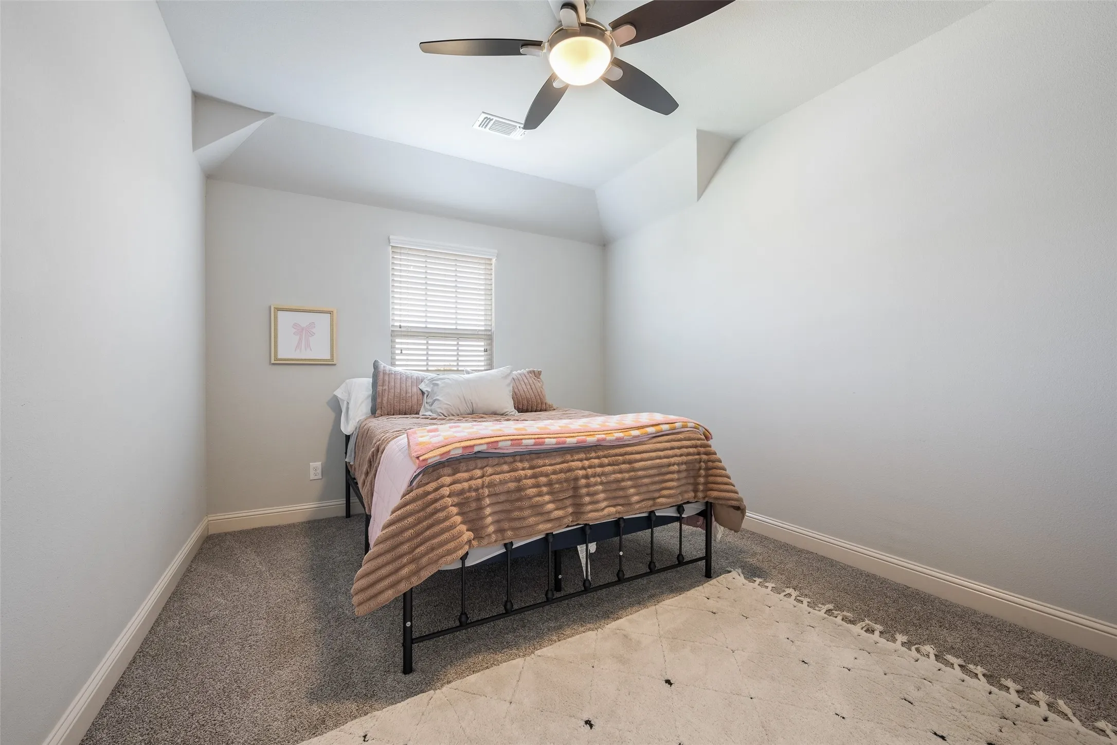 Carpeted room featuring a ceiling fan with integrated lighting, a window with blinds, and white trim