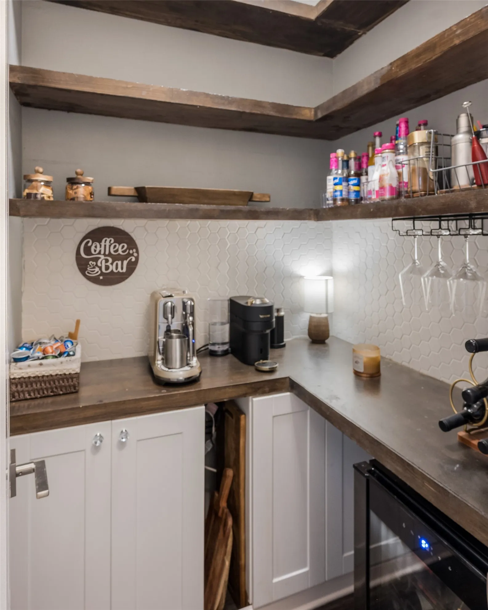 Dedicated coffee bar featuring exposed wood-beam ceiling detail, white shaker cabinetry, wood-finish countertops, and stainless steel appliances including dual coffee makers