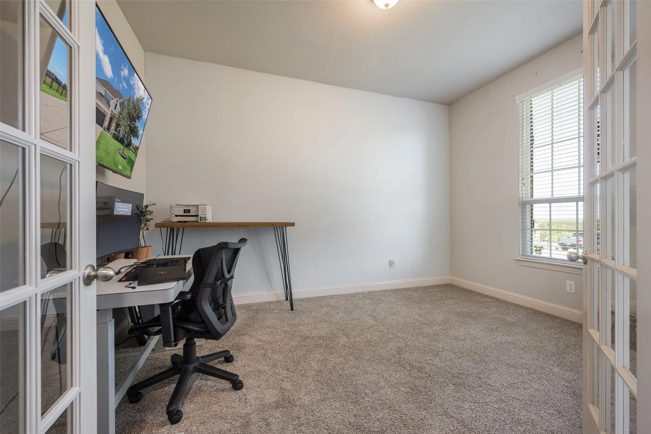 French doors with glass panels, carpeted flooring, single window with blinds, and a built-in ceiling light fixture