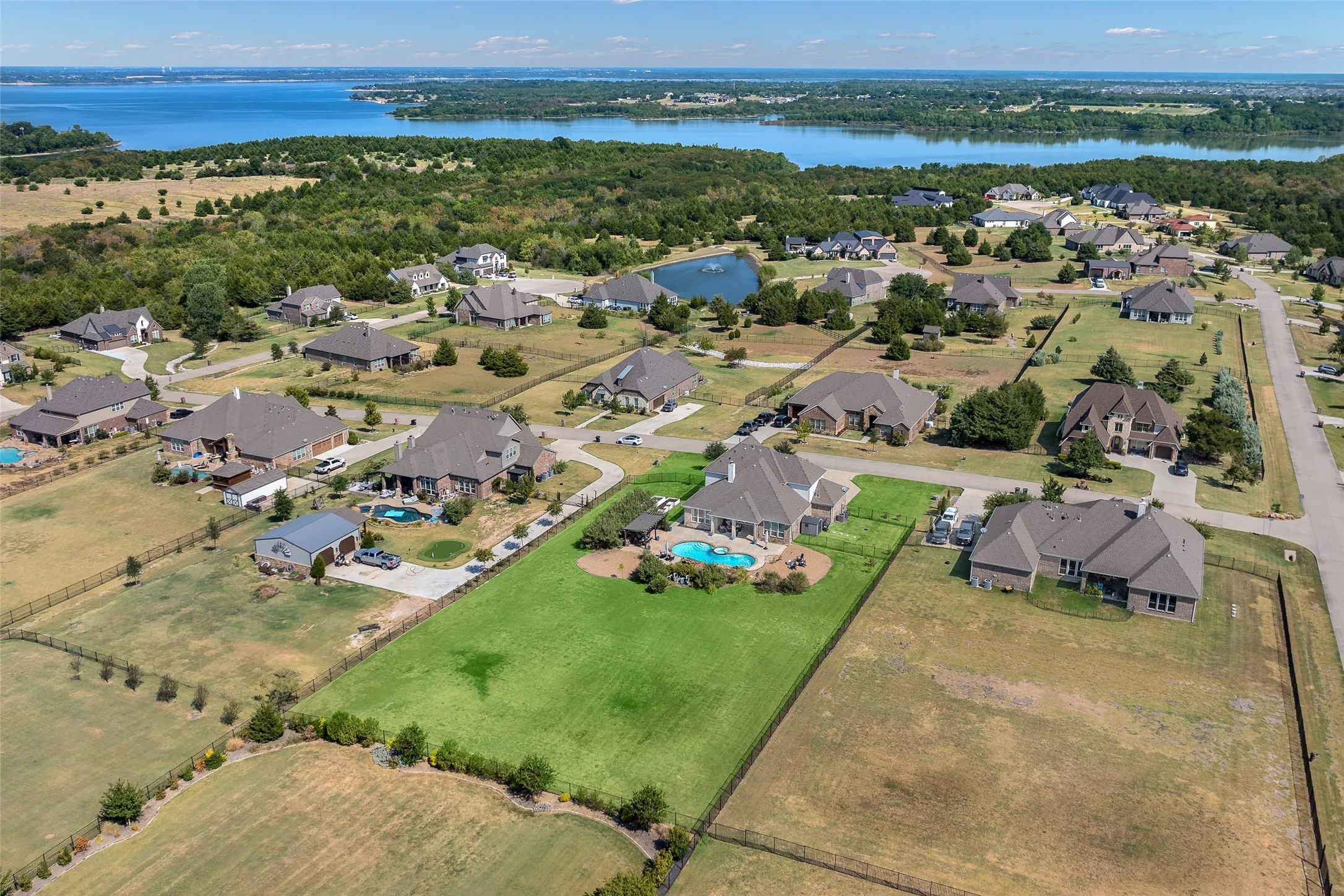 Expansive property featuring a private swimming pool, detached garage, and a large manicured lawn