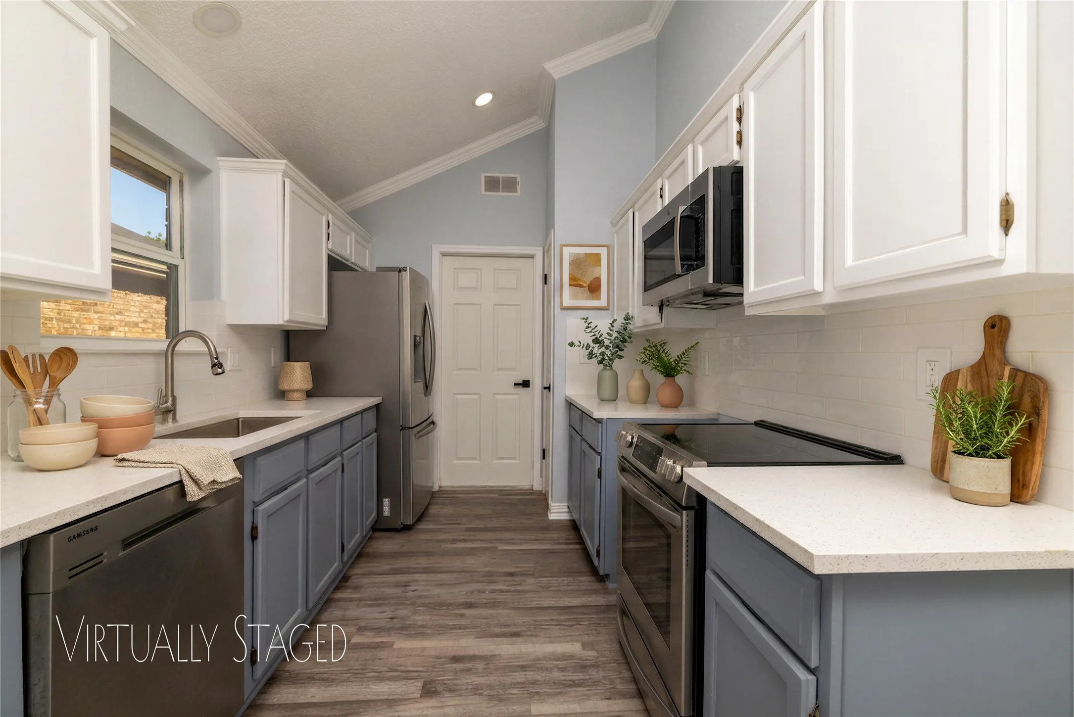 Kitchen featuring wood-like LVP  flooring, two-tone cabinetry, stainless steel appliances, white countertops, and a white subway tile backsplash