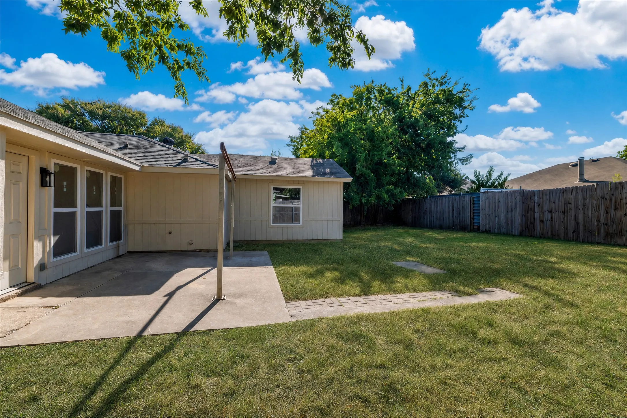Expansive green lawn with a privacy fence