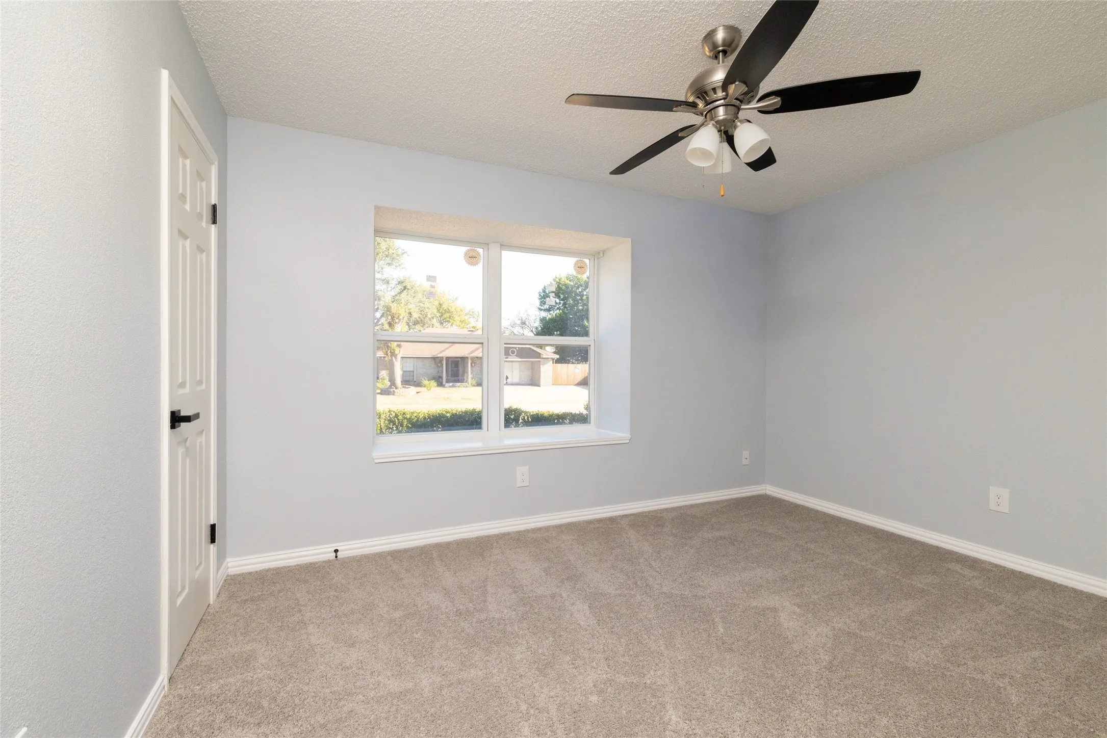 Recessed window with white trim, light gray walls, and textured ceiling