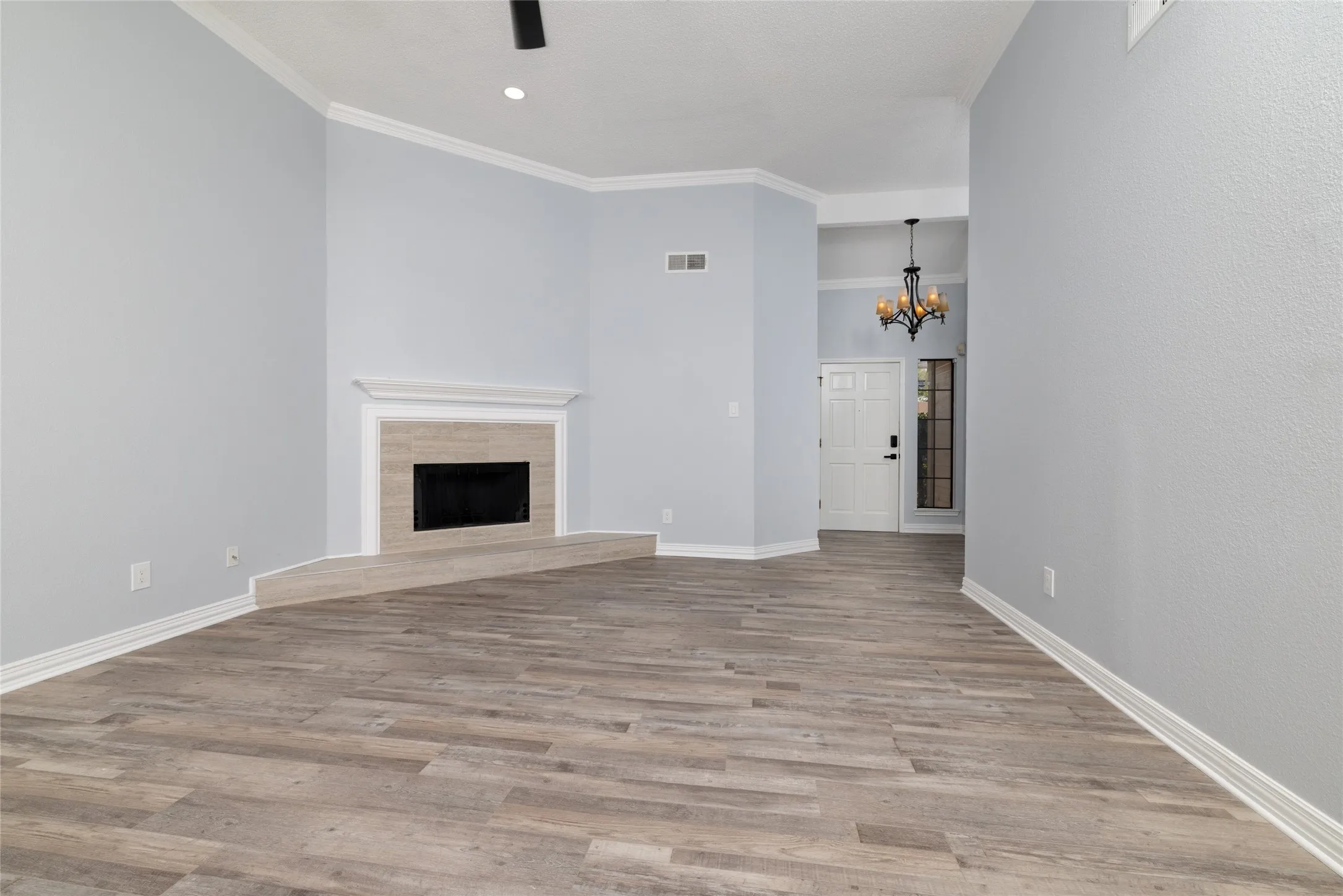 Wood-finish flooring throughout, featuring a fireplace with a tile surround and hearth