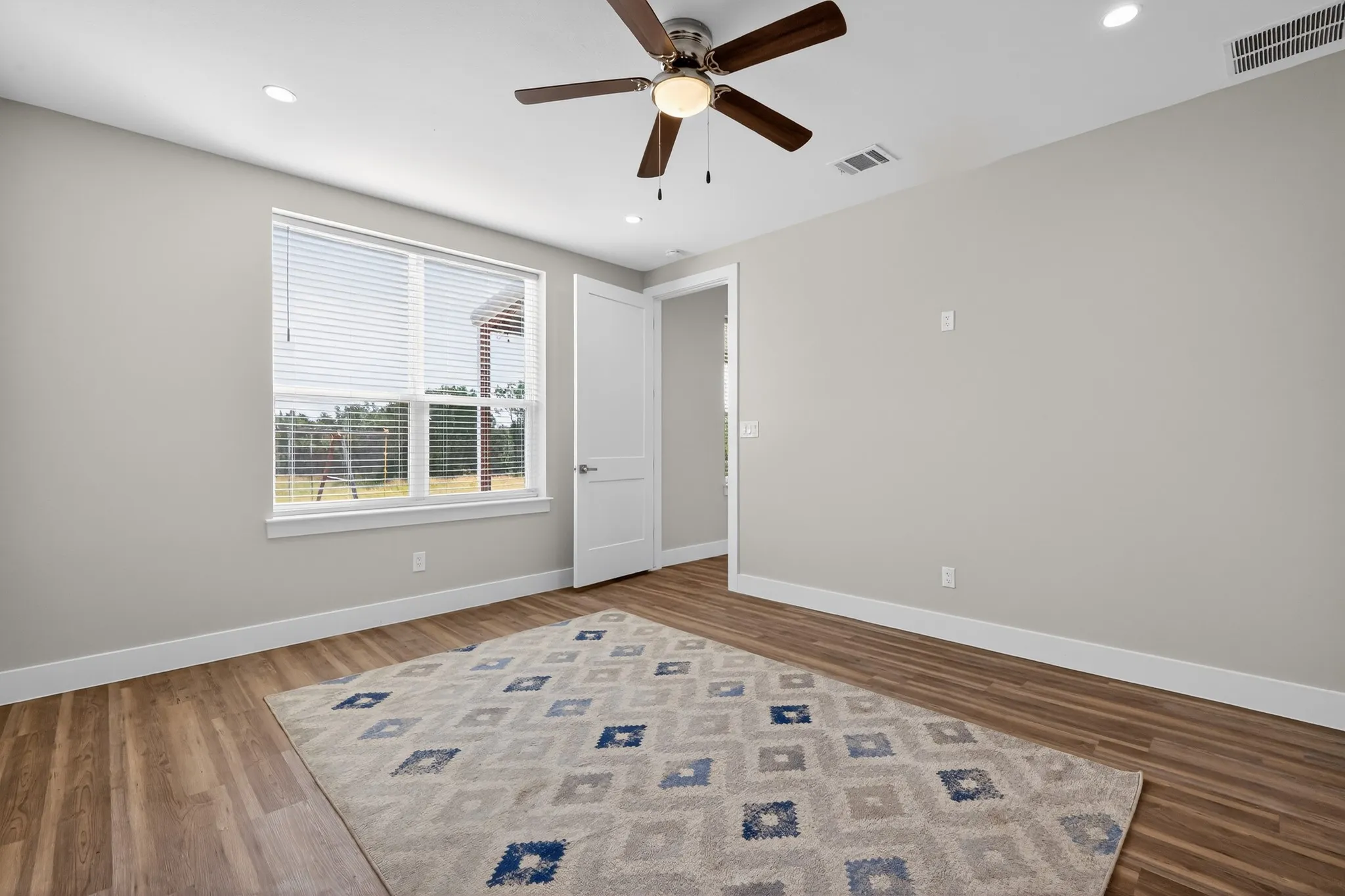 Recessed ceiling lighting, wood-finish flooring, ceiling fan with integrated lighting, white window blinds, and white trim