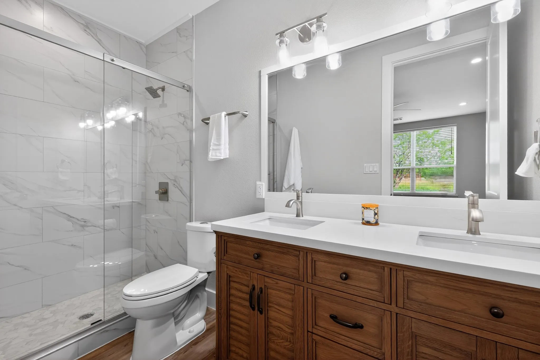 Dual vanity with integrated sinks, wood-finish cabinetry, and brushed nickel faucets