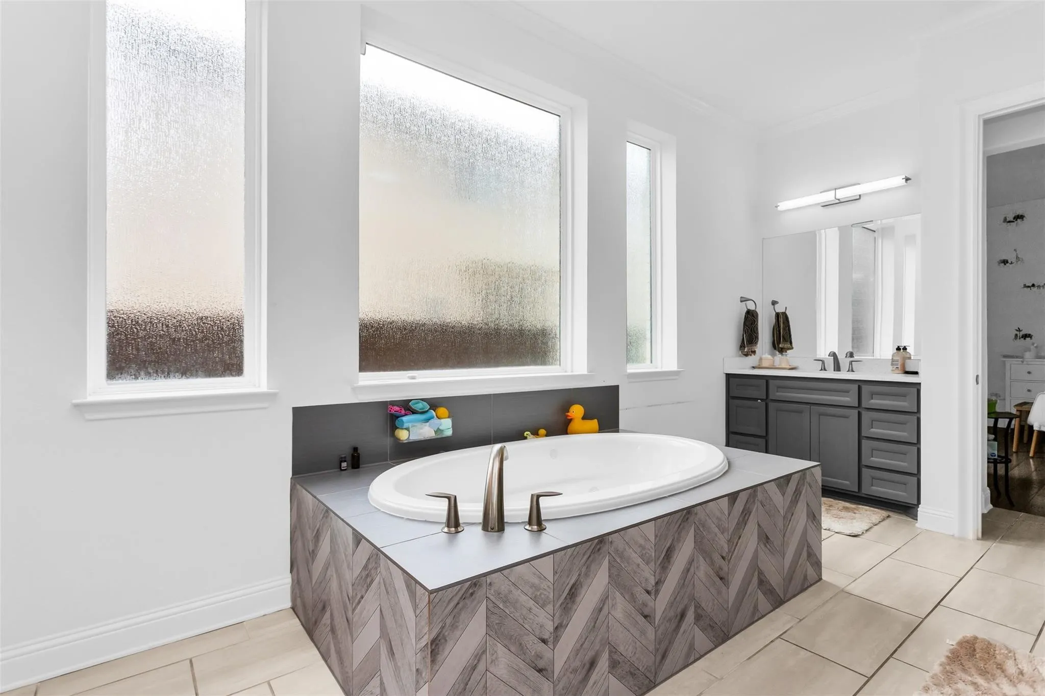 Integrated oval soaking tub with chevron-patterned tile surround
