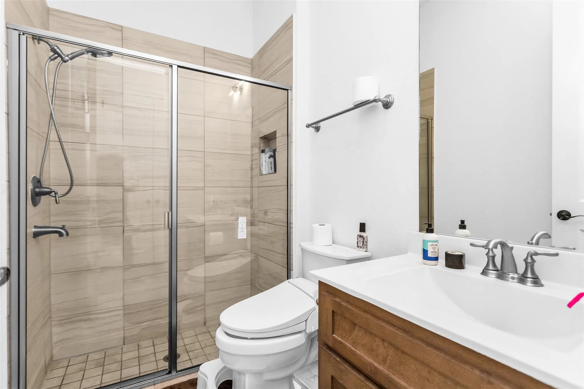Glass-enclosed shower with a tiled surround and built-in niche