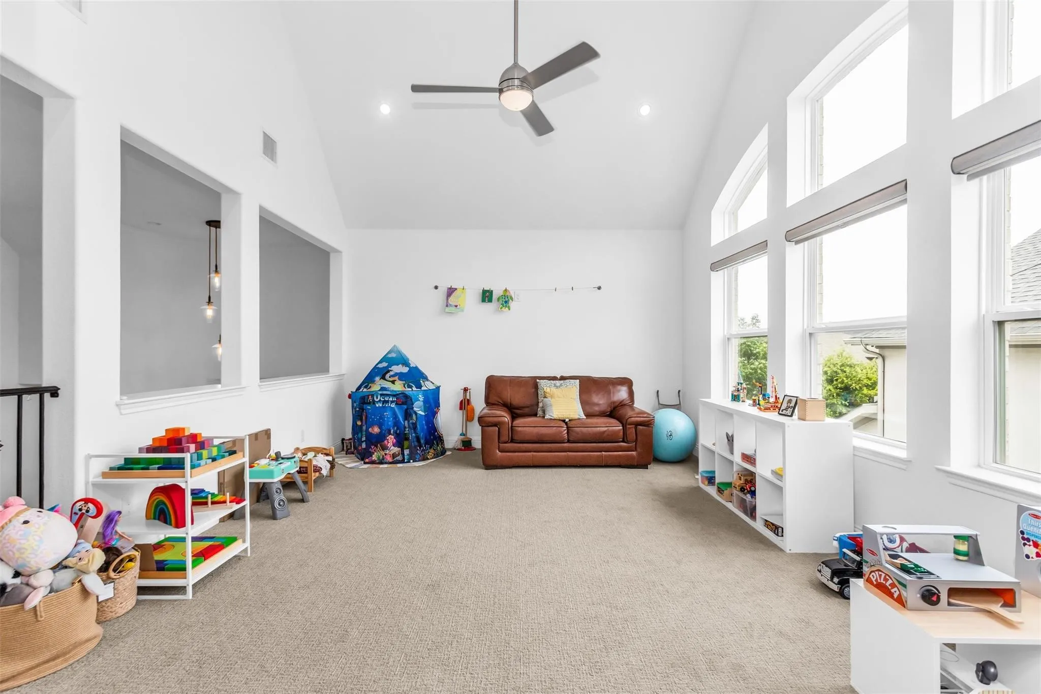 Vaulted ceiling featuring a ceiling fan and recessed lighting, multiple windows with blinds, and carpeted flooring