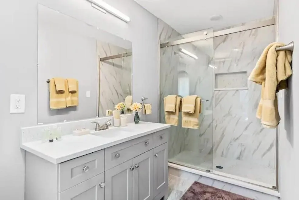 Vanity with light gray cabinetry and white countertop