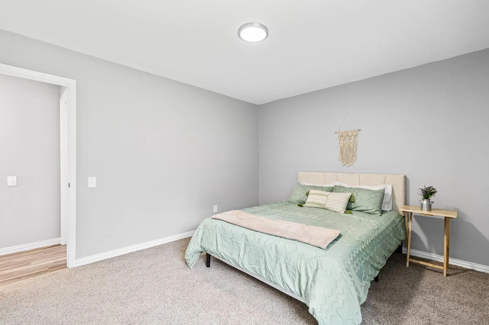 Carpet, light gray wall finishes, recessed lighting, and a neutral upholstered headboard