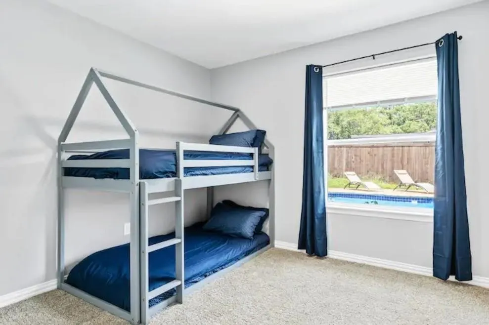 Carpeted room featuring a window overlooking a swimming pool