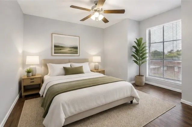 Hardwood-style flooring, ceiling fan, large window with blinds, and neutral wall tones