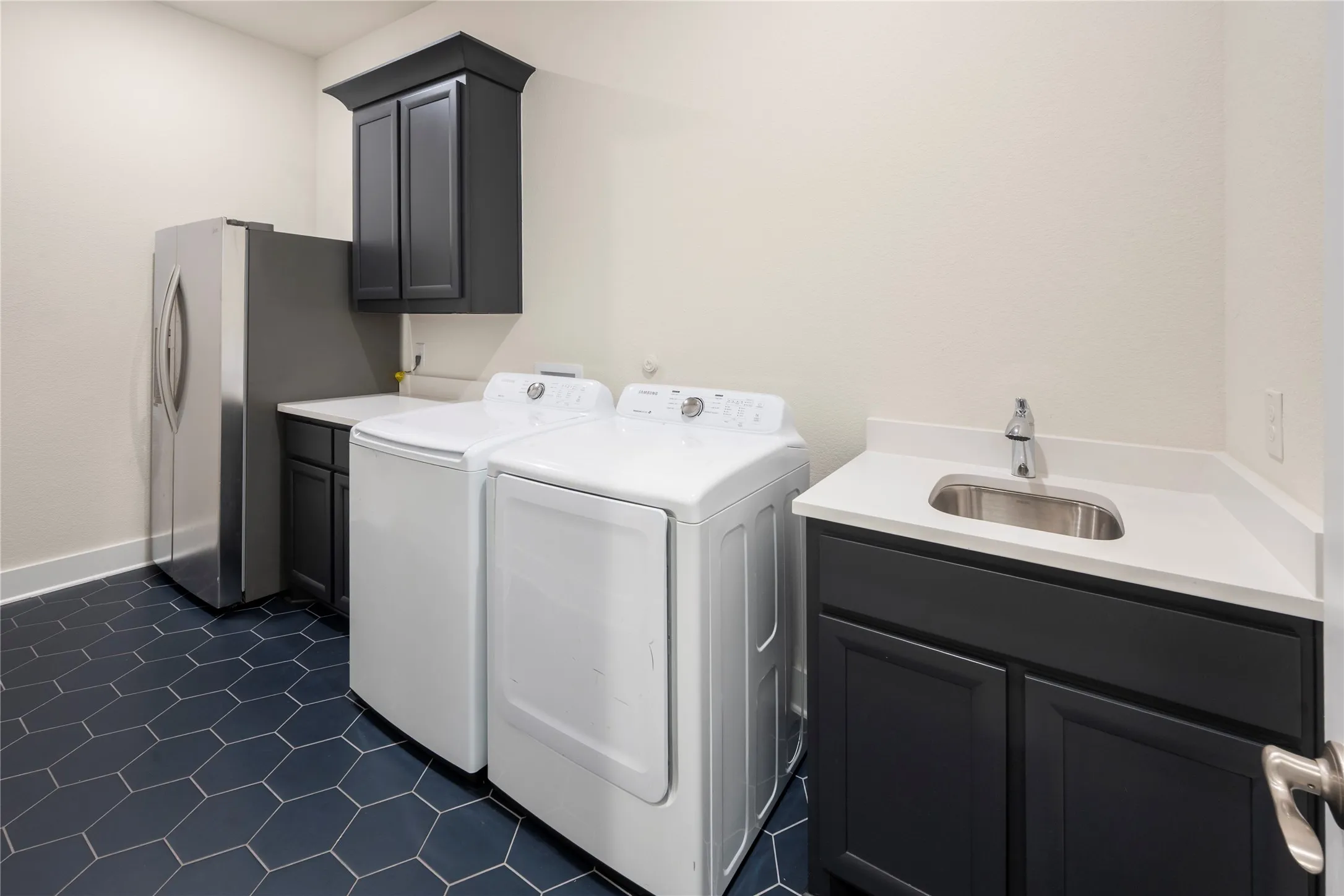 Sink and extra refrigerator in the laundry.