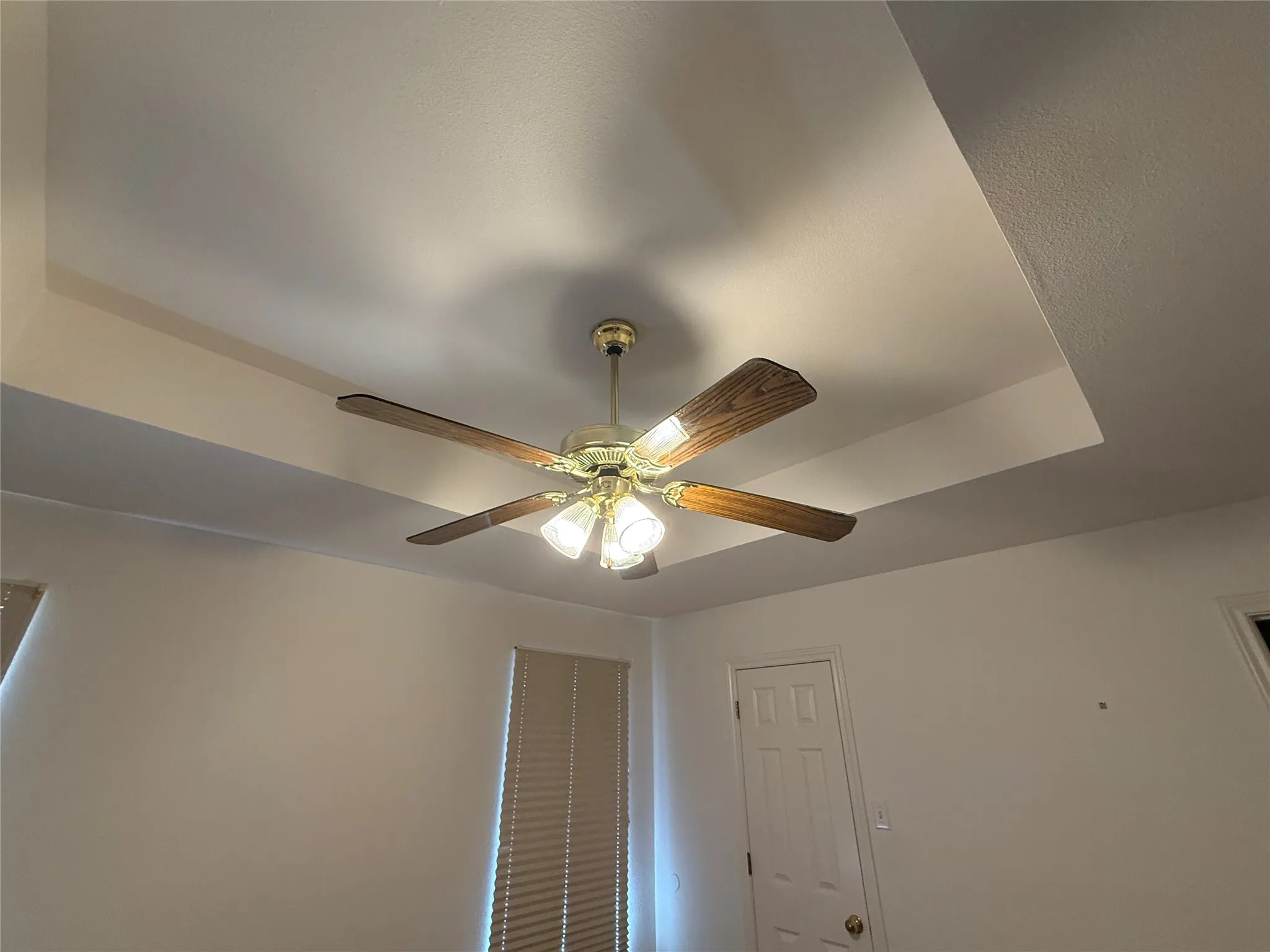 Recessed tray ceiling with a brass-finish ceiling fan and light fixture