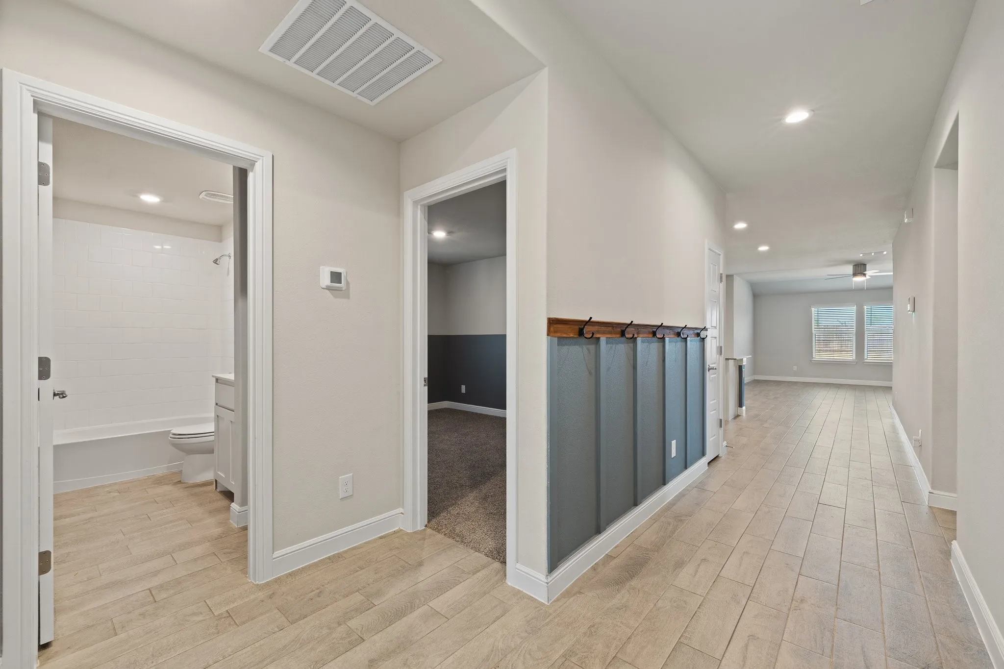Wood-finish flooring throughout the hallway and bathroom