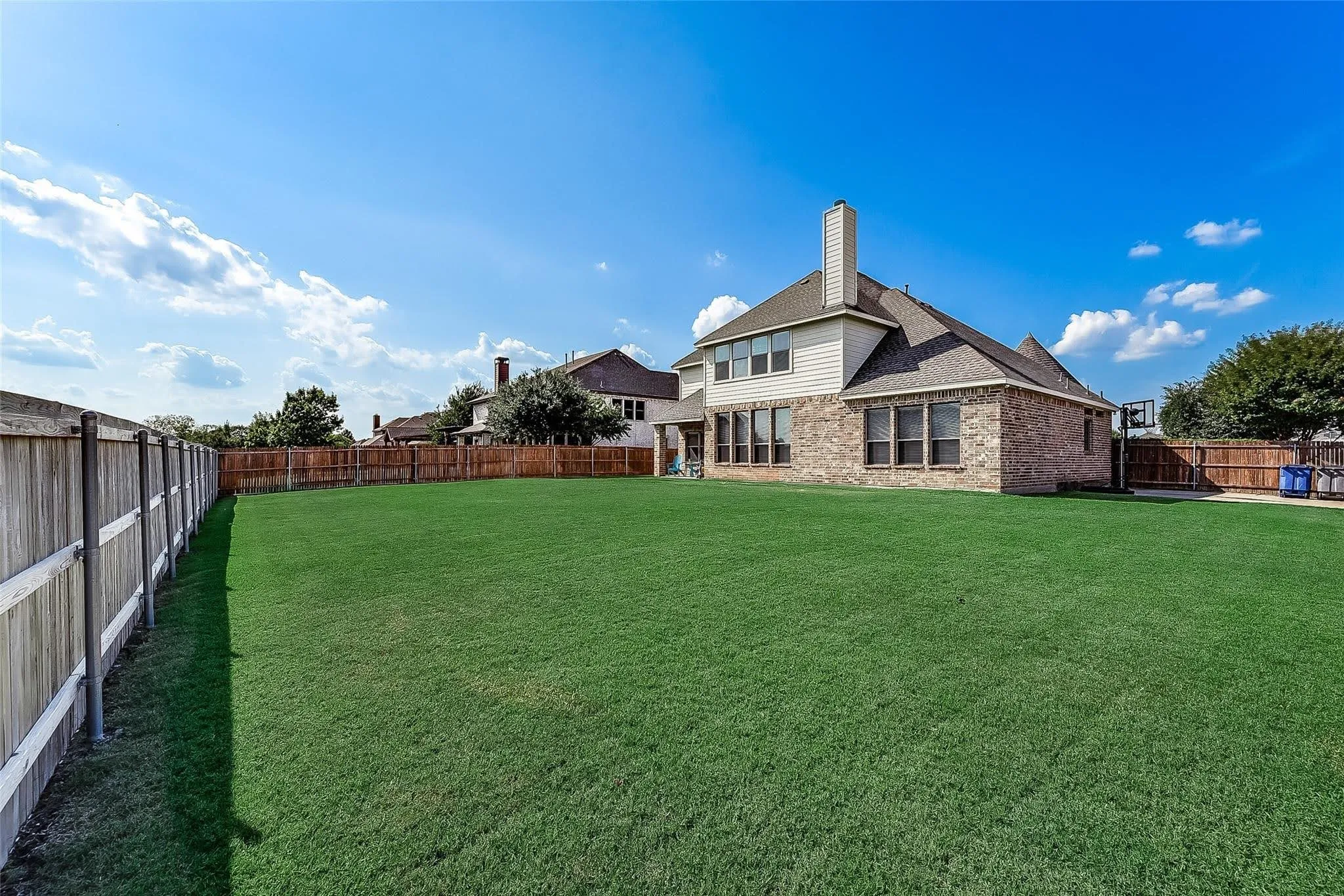Expansive green lawn with a privacy fence