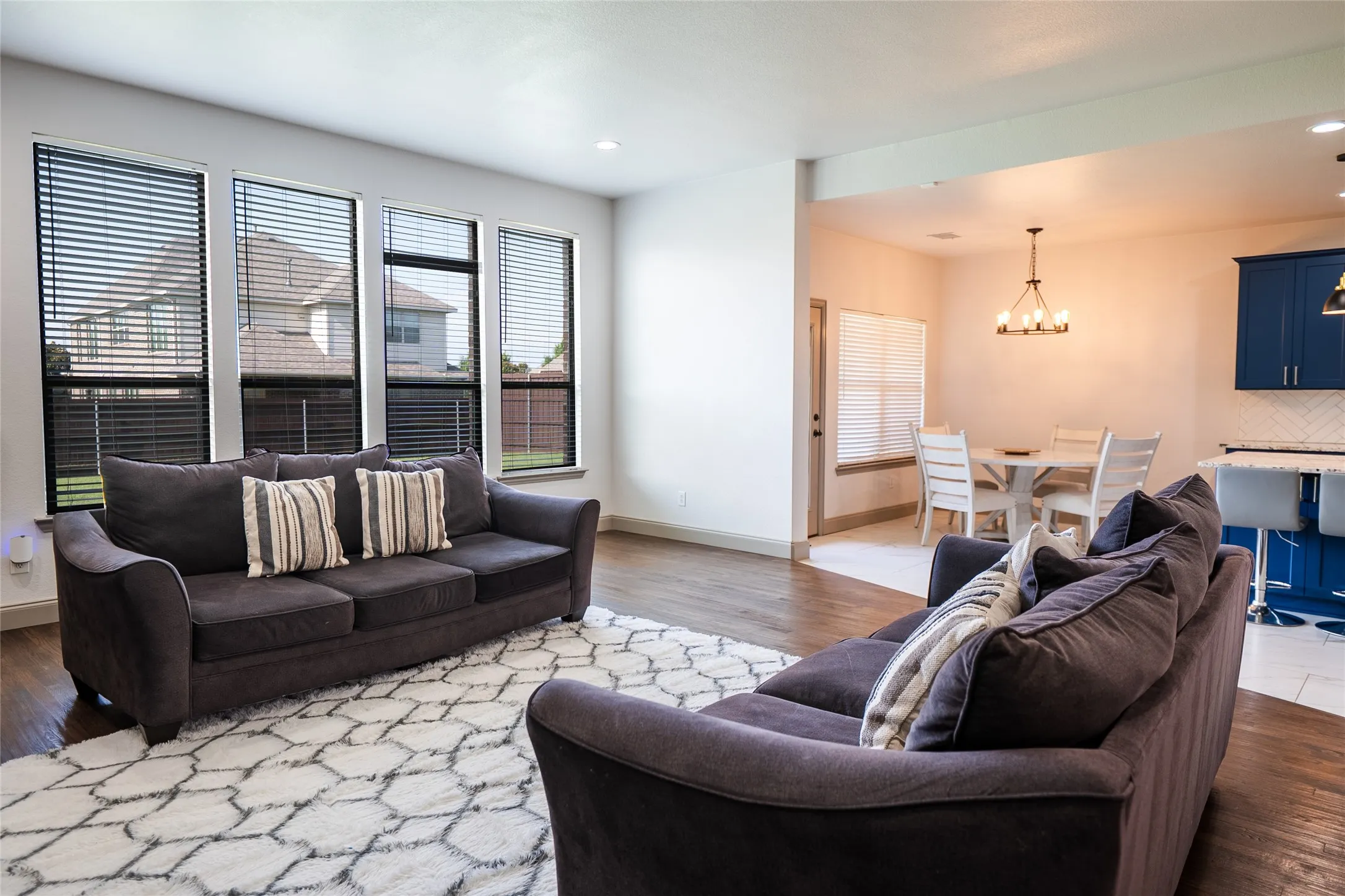 Recessed lighting, wood-finish flooring, multiple large windows with blinds, and an open concept layout