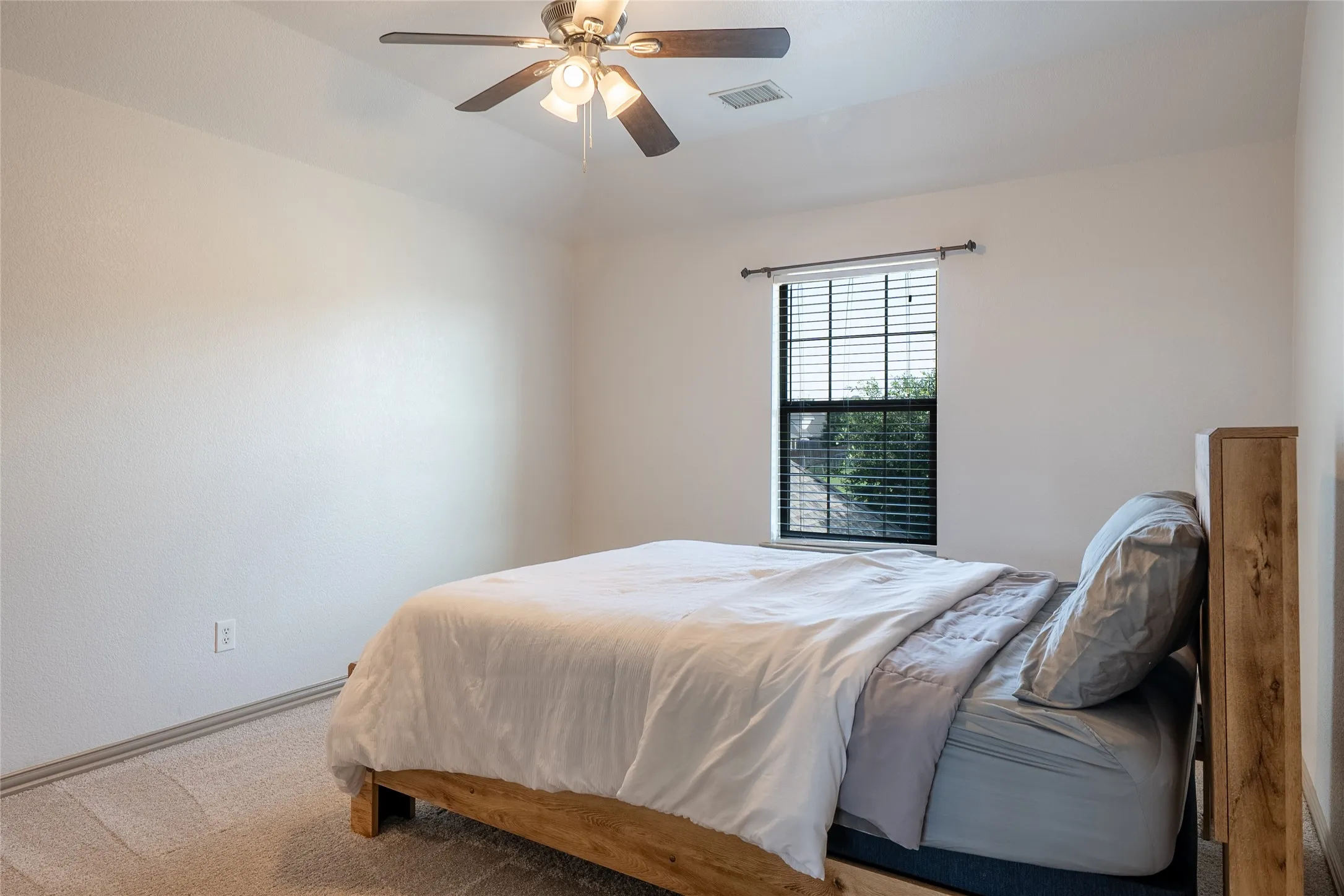 Vaulted ceiling, ceiling fan with light fixture, carpeted flooring, window with blinds