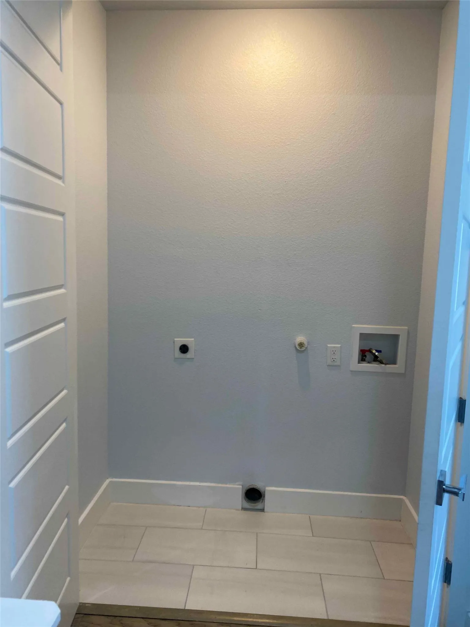 Laundry area featuring hookup for a full size washing machine, electric dryer hookup, gas dryer hookup, and light tile patterned flooring